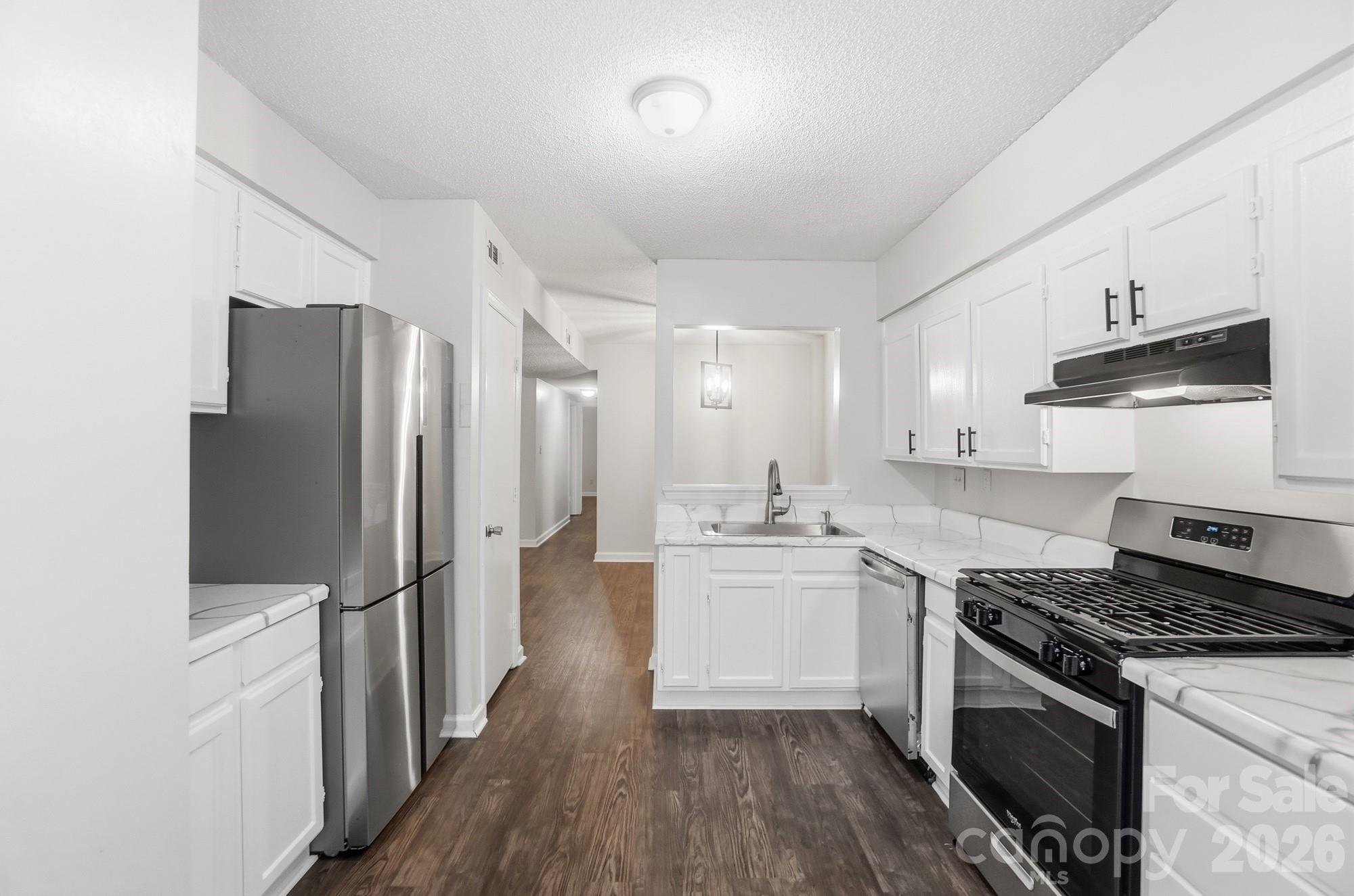 Welcome home to this ground floor updated 2 bed, 2 bath condo in Forest Ridge! This move-in ready condo is a fantastic opportunity for investors, first time homebuyers or those looking for a low maintenance lifestyle. This end/corner unit provides additional windows and natural light, vinyl flooring throughout, upgraded SS appliances, spacious living room and private screened patio! Entertain with your dining room right off the kitchen and living area. Unwind from the day in your oversized primary bedroom, en-suite and walk-in closet. The bonus/flex room off of the living room is a great opportunity for an office, plant room, or even 3rd bedroom with some creativity. Conveniently located right by the parking area with paved walkway right to your front door. Come see for yourself what Forest Ridge has to offer including community pool, prime location for those getting to Uptown, Plaza Midwood and so much more.