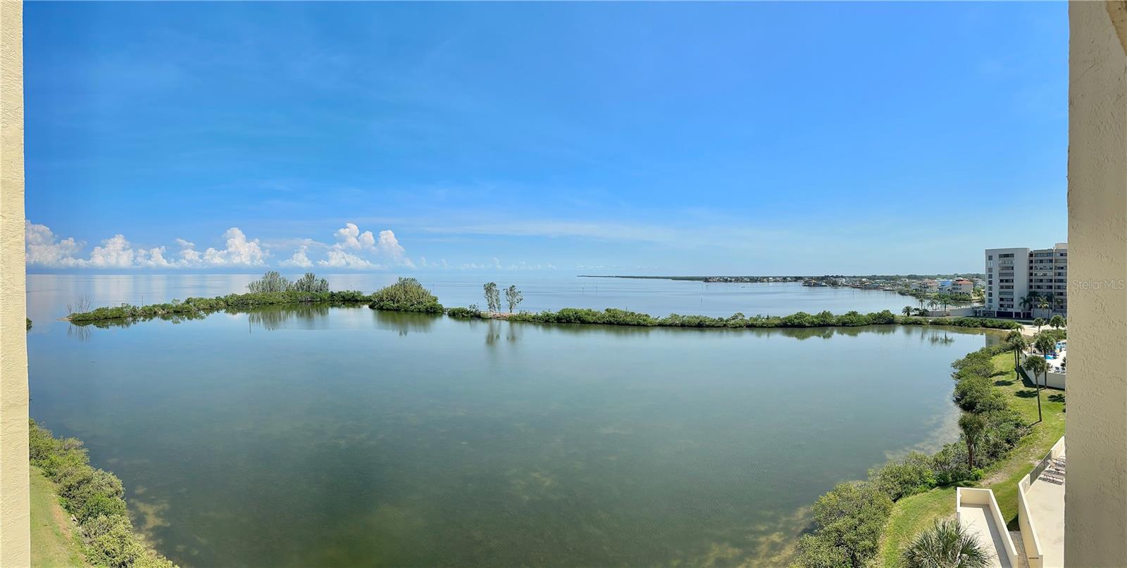 SOAK IN NATURE'S SPECTACULAR WATER AND SUNSET VIEWS, each and every day of the year in this Gulf Front Oasis. Newer Kitchen features self closing cabinet doors, mosaic glass back splash, coffee bar and closet pantry with Southern water views through the kitchen window and is fully equipped with everything needed to prepare ad serve your favorite meals. The open interior with gorgeous 24 inch high gloss porcelain floor tiles flows beautifully with mesmerizing water views from all the rooms. Crash in the comfy power recliner love seat watching your favorite show or enjoy the warm ambience of the electric fireplace. Relax on your open air covered balcony with your favorite beverage or meal enjoying your "Nature's Paradise" soaking in the water views, summer sunsets. and soothing Gulf breezes  watching the dolphins swim , manatees float, and birds soar by. The island paradise is surrounded by water except for the 24/7 guarded entry for your upmost security. This resort style neighborhood features beautiful olympic sized temperature controlled swimming pool, private sandy beach, Nature's trail, sunbathing promenade overlooking sparkling lagoon, waterside picnic area, tennis & pickleball courts, fishing , and kayak storage. Mingle with friends and family in the remodeled clubhouse boasting large function room where the community features multiple social events during the year , grab a coffee or ice from the complimentary refreshment center, compete in  two game rooms, exercise in the waterfront fitness center with locker rooms, or use the  fully equipped workshop. Assigned parking spaces and boat slips in the community Marina become available to purchase or rent occasionally. The monthly maintenance fee includes all amenities, 24 hour guards, and all the utilities including cable and Wifi except electricity. Milestone Inspection is done and minor repairs completed with no special assessments as have been common in other area waterfront condo communities. Ideally located in quiet Hudson Beach close to waterfront restaurants and casual beach bars that are easily accessible by boat or vehicle. Enjoy multiple area State Beaches and Parks, golf courses, shops, and the close by Sun West Water Park. Easy access to all that the Tampa Bay and the St Pete/Clearwater areas have to offer day or night. This community is one of the Best Waterfront values and Best kept secrets around. View the community tour to walk along the Nature's Trail , past the beach & pool , through the clubhouse, and fly over the community. Live the great Florida Gulf front lifestyle without the fear of being flooded !! Call today for Your Virtual or Private in person viewing.