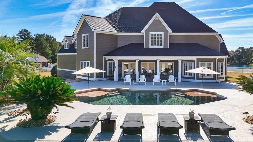 Waterfront Luxury Home with Backyard Oasis- Welcome home to 1333 Gatlin Creek Road, a private Thomas County retreat where luxury, comfort, and everyday living blend effortlessly. Set on nearly 3.5 acres with shared access to a beautiful 5-acre pond, this meticulously maintained 4-bedroom, 4.5-bath home welcomes you with a circular front drive and invites you into a lifestyle that feels both elevated and warmly familiar.  From the moment you step inside, the rich hardwood floors, custom millwork, and thoughtful architectural details create a sense of timeless Southern elegance. The formal dining room sets the tone for holidays, special dinners, and celebrations that flow easily throughout the home. The spacious living room, anchored by a gas fireplace and surround sound, becomes the heart of daily living—cozy on quiet evenings and perfect for gathering with friends and family.  The chef's kitchen is where the magic of everyday moments happens—morning coffee at the breakfast room windows, meal prep on expansive cambria countertops, and hosting made easy with cherry cabinetry, a large island with vegetable sink, bar seating, brick backsplash, built-in oven and microwave, and a huge walk-in pantry. This kitchen was designed for living, gathering, and feeding the people you love.  Two bedrooms sit on the main level, including the luxurious primary suite—your personal retreat. With two oversized walk-in closets, a spacious sitting area opening to the pool and covered porch, and a spa-like bath featuring double vanities, makeup area, and tiled walk-in shower, it's a sanctuary you'll look forward to coming home to.  Upstairs, the home transforms into the ultimate entertainment space. A massive game room/mancave offers a bar/kitchen area, theatre seating, built-in entertainment center, two built-in twin beds, and surround sound—perfect for family movie nights, big games, holiday parties, or the coolest sleepovers in town. This level also includes loads of attic storage, keeping everything organized and out of sight.  Then there's the outdoors—the part that truly sets this home apart. Step outside to a saltwater inground pool, fresh pool decking, built-in gas grill, firepit, and a wide-open yard framed by a beautiful shade oak. It's your personal oasis for summer afternoons, fall bonfires, and quiet moments at the end of the day.  And just beyond the yard lies the 5-acre fishing pond, stocked and ready for memories. Picture slow, peaceful mornings casting a line as mist rises off the water, kids catching their first bream off the bank, or easy Sunday afternoons reeling in bass while the sun sets behind the trees. It's the kind of simple, grounding joy you can't buy in a neighborhood—your own private escape where every cast feels like a reset.  With a brand-new roof, triple-car garage, office, downstairs laundry, and easy access to Publix, Lowe's, restaurants, schools, and downtown Thomasville—just 10 minutes away—you get privacy, convenience, and luxury in one perfect location.  This is more than a home. It's a lifestyle—quiet mornings by the pond, unforgettable gatherings in the game room and backyard, room to breathe, and the comfort of knowing this is where your best memories will be made.