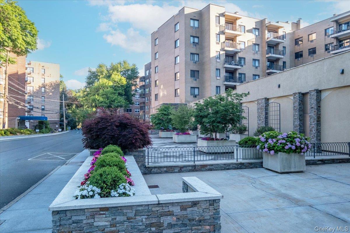 Welcome to this beautifully updated and spacious two-bedroom, two-bath residence with a versatile bonus area ideal for a home office, den, or reading nook. Located in one of Hartsdale’s most desirable buildings, this home offers deeded indoor parking and the convenience of laundry on the same floor. The bright, expansive living and dining areas are designed for comfortable everyday living and effortless entertaining. Sliding glass doors open to a large private terrace overlooking the beautifully landscaped courtyard, creating a peaceful outdoor retreat. The updated kitchen features granite countertops, all-new cabinetry, and stainless steel appliances, flowing seamlessly into the main living spaces. Recent improvements include recessed lighting, renovated bathrooms, and tasteful updates throughout. The generously sized primary suite features a renovated en-suite bath, while the spacious second bedroom offers abundant closet space and large windows that fill the home with natural light.Ideally located just moments from the Metro-North Railroad station, shopping, restaurants, entertainment, and the popular seasonal farmers market, this exceptional home offers the perfect blend of comfort, style, and convenience in the heart of Hartsdale.