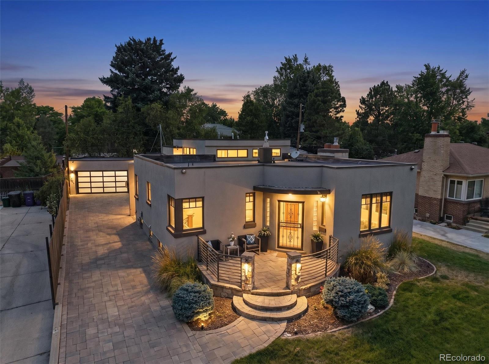 Rarely does a 1941 Streamline Moderne residence of this caliber become available in Montclair. Thoughtfully expanded and reimagined in 2012, this architecturally significant home blends historic character with contemporary luxury while offering the ease of one-level living. Original coved ceilings, oak hardwood floors, and a honey onyx fireplace set the stage for beautifully designed living spaces. The designer chef's kitchen features Sub-Zero and Wolf appliances, Ann Sacks tile, heated floors, custom cabinetry, walk-in pantry, breakfast nook, and a rare petrified stone breakfast bar. The light-filled great room impresses with soaring beamed ceilings, oversized windows with motorized shades, a Bronze Amani marble fireplace, custom entertaining bar, and French doors opening to a private courtyard.The primary suite offers vaulted ceilings, a custom closet, and a spa-inspired bath with heated floors, floating dual vanities, backlit LED mirrors, natural stone finishes, and a sculptural walk-in shower. Two additional bedrooms share a beautifully renovated bath featuring Brazilian Macaubas quartzite. The finished lower level includes a private guest suite, luxurious spa bath with Carrara marble, and an extraordinary climate-controlled Italian-inspired wine cellar with barrel-vaulted ceilings, custom wine racks, tasting bar, wet bar, and Bacchus fountain.Outdoor living is designed for year-round enjoyment with a covered courtyard featuring a cedar-planked ceiling, retractable awning, fire pit, patio heater, built-in gas grill, and professionally landscaped, low-maintenance backyard. A newly installed roof, detached two-car garage built in 2012, and an expansive paver driveway providing generous off-street guest parking complete this exceptional offering, ideally located near Cherry Creek, 6th Avenue Parkway, Lowry, neighborhood parks, and local dining.