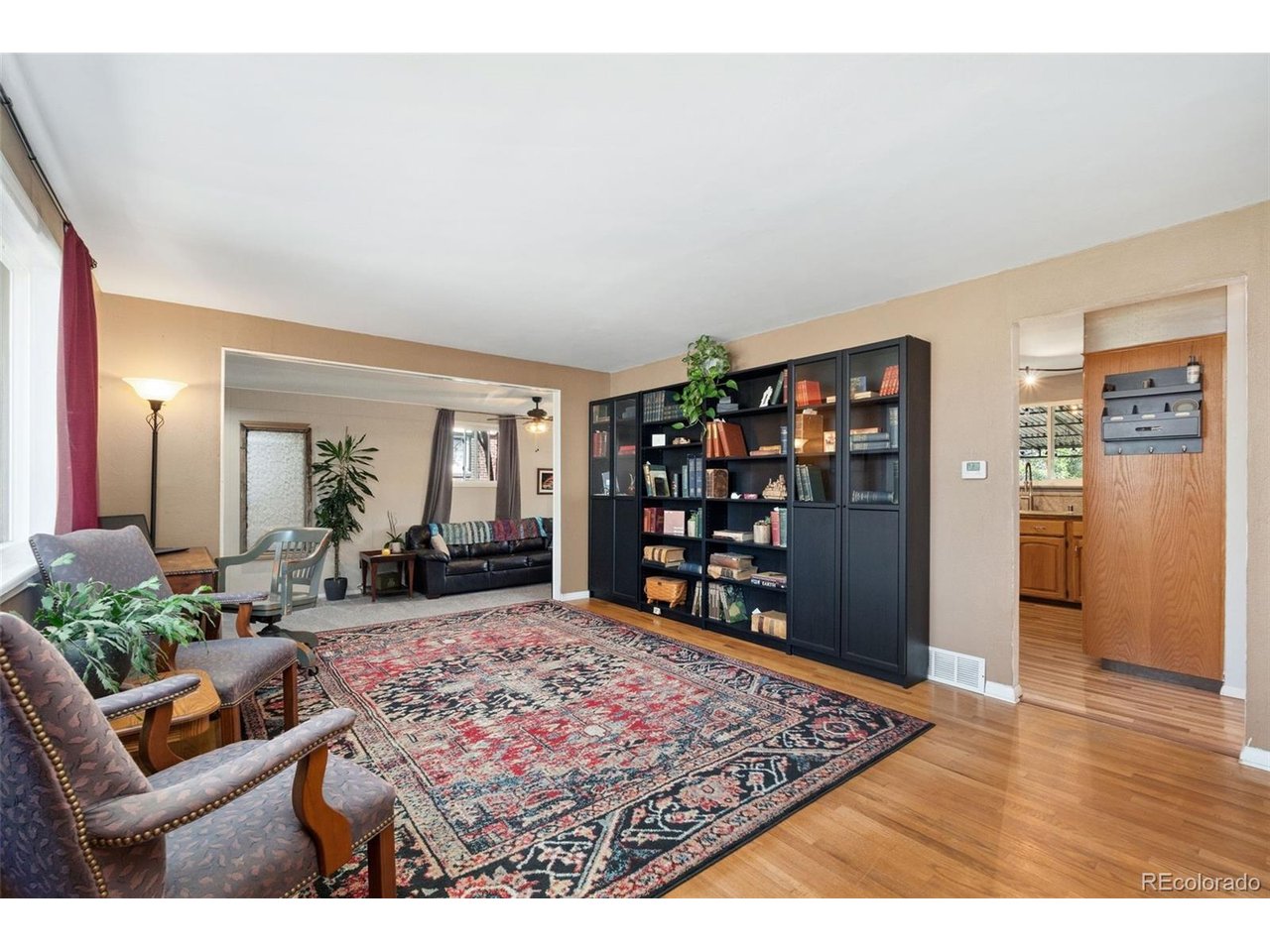 Classic brick Cape Cod charm meets comfortable living in this 4-bedroom home. Original hardwood floors, dormer windows and timeless architectural character add personality, while the connected layout makes everyday living easy. The formal living room flows into a cozy den with a fireplace, then connects naturally to the kitchen and covered back patio, creating a circular floor plan ideal for relaxing, gathering and entertaining. The eat-in kitchen offers granite counters, abundant storage, open shelving, newer appliances, a backyard view and space for a breakfast nook. The two cheerful main-floor bedrooms have original wood floors, the second bedroom has a laundry closet and could serve as a perfect guest room, office or flex space. Upstairs, the primary bedroom features a walk-in closet, original wood floors, charming window dormers with abundant light and an adjacent updated stylish full bath. A second upstairs bedroom also offers a walk-in closet and original wood floors. Outside, the large landscaped backyard is designed to be enjoyed, with a cool covered patio, spacious lawn, sandy play area, dedicated garden space and a storage shed. There is room for outdoor dining, entertaining, play and gardening. No HOA, driveway parking and an 8,520-square-foot lot add flexibility. Important improvements are already in place, including a new roof installed in September 2025 with hail-resistant shingles and a transferable warranty, a new electrical panel and a newer furnace. Quick access to I-25, I-70 and Downtown Denver also makes commuting and getting around the metro area convenient. The Enterprise Zone location may provide additional benefits for certain home-business uses; buyer to verify.