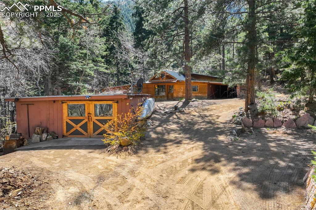 Nestled among the trees in the heart of Cheyenne Canyon, this charming 2-bedroom, 1-bathroom log cabin offers a rare
blend of rustic character and tranquil living. Set on a beautifully treed lot with the soothing sounds of a nearby creek, this
home invites you to unwind and connect with nature. Step inside to find a cozy living room featuring vaulted ceilings,
skylights, concrete floors, exposed log beams, and a wood-burning fireplace—perfect for chilly Colorado evenings. The
partially renovated kitchen includes a new gas stove/oven and provides a solid foundation for your own personal updates.
The primary bedroom offers a unique bonus space that can serve as a sitting area, office nook, or walk-in closet. The second
bedroom is truly a treehouse-style sanctuary, surrounded by windows on three sides for a 260-degree view of the natural
beauty outside and abundant natural light throughout the day. The updated bathroom features a dual vanity, newly tiled
walk-in shower, a classic clawfoot tub, and built-in storage for linens. Additional highlights include: mini-split A/C system
for year-round comfort, covered carport that doubles as a workshop area, private neighborhood access to hiking trails, close
proximity to Helen Hunt Falls, Seven Bridges, North Cheyenne Cañon Park, and outdoor recreation opportunities galore.
Whether you're looking for a full-time residence, a peaceful weekend getaway, or an investment with charm and character,
this property offers endless potential to make it your own mountain retreat.
