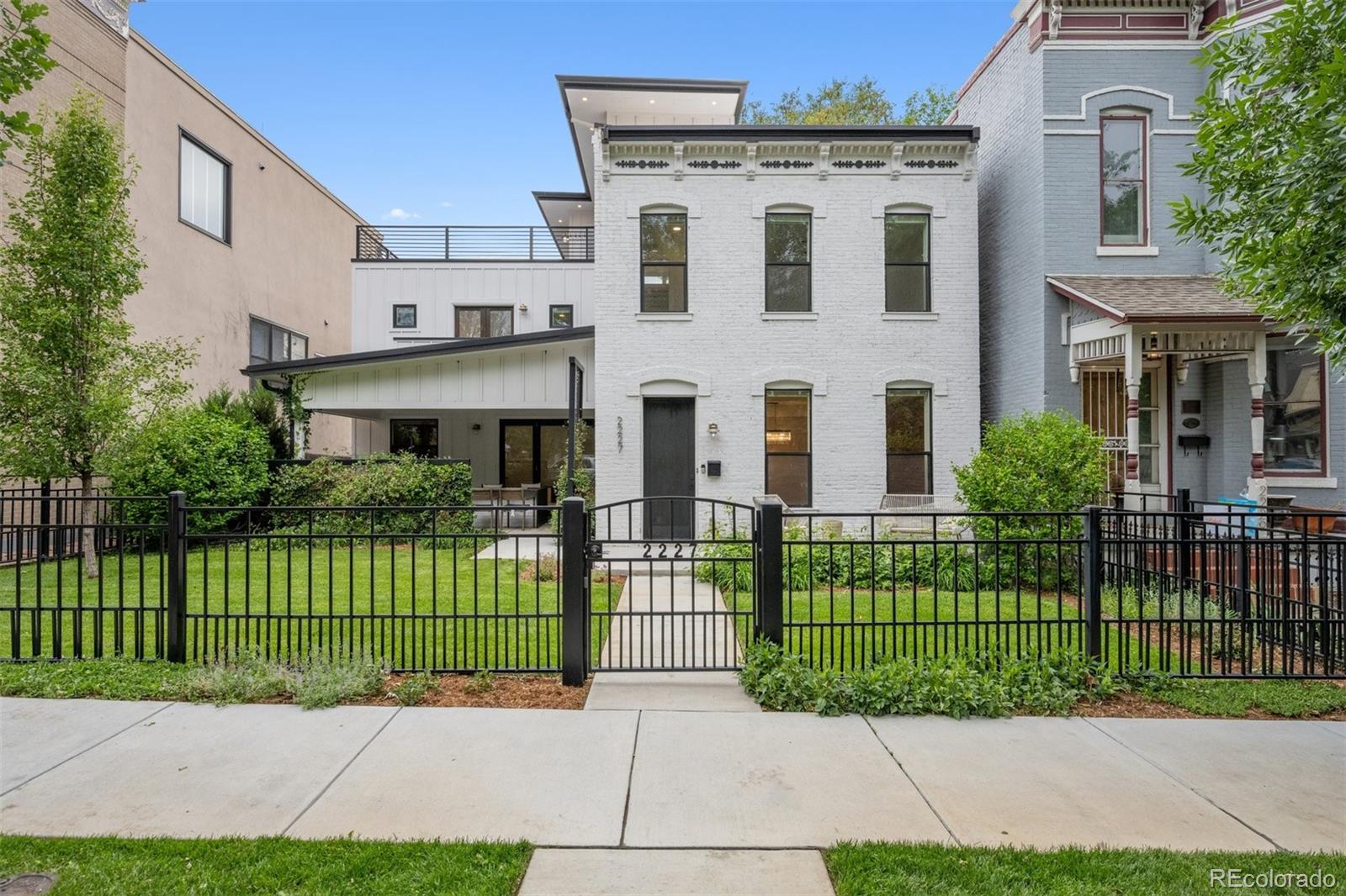 Rare opportunity to own a luxury residence on a coveted double lot in the heart of Denver. This exceptional property features 6 bedrooms and 6 bathrooms, showcasing custom finishes throughout, hardwood floors, exposed brick, elegant wrought-iron railings, custom kitchen cabinetry, and designer details at every turn. The luxurious primary suite offers custom closets, a private balcony, coffee bar with beverage refrigerator, and a spa-inspired marble steam shower with integrated audio speakers. Entertain effortlessly in the third-floor loft featuring a wet bar and beverage refrigerator, or enjoy breathtaking Downtown Denver and mountain views from the spectacular rooftop lounge. The property is fully enclosed by a custom wrought-iron fence with a private gated driveway and includes a 3-car garage. A detached carriage house/ADU offers 2 bedrooms, 2 bathrooms, out of the tota beds and baths with an attached gym, and private laundry, creating the perfect space for guests, multigenerational living, a home office, or potential rental income. A truly rare offering that combines luxury, flexibility, privacy, and unmatched outdoor living in one remarkable property. Welcome home.