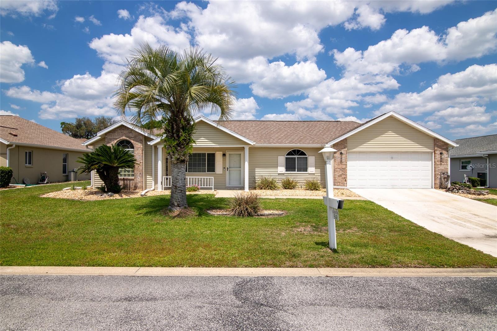 This Ocala Palms Pinto II model is absolutely picture perfect - inside and out! Every detail has been attended to in this 2 bedroom, 2 bath home with 2 car garage. From the moment you arrive at this property you will feel welcomed. The views of the golf course and pond from the front porch are just picturesque! The living room features vaulted ceilings and gorgeous porcelain tile which is throughout the home - that's right - no carpet! Updated kitchen with wood cabinetry, quartz countertops, new ceramic tile backsplash and spacious pantry. Eat in area in the kitchen with bay window too. Generously sized indoor laundry just off of the kitchen. Split bedroom plan. Master suite is very well designed with spacious bedroom featuring tray ceiling, walk in closet, and updated bathroom with plenty of counter space, walk in glass enclosed shower and separate tub and lots of natural light! The spare bedroom also features a tray ceiling and is just off of the spare bathroom. The enclosed lanai includes a stand alone A/C unit making this an all season room to enjoy! Paver patio off of the lanai is the perfect place to grill or sunbath or both! Situated in a newly chain link fenced backyard that features palm trees and very tasteful landscaping. It is evident that this home has been well loved and cared for and little extras throughout including marble window sills. Several recent updates within the past year include modern farmhouse light fixtures inside and out, new dishwasher, new front storm door with screen, new cabinet hardware in both bathrooms, new door handles throughout - including entry doors. Fresh landscaping out front too! New door with doggie door and new motion detection lighting in the backyard. New roof in 2015 and recently serviced HVAC! All situated within 2 miles of the World Equestrian Center - a world-class facility. Which is also the largest equestrian complex in the United States situated on nearly 378 acres nestled in the Horse Capital of the World. The decor in this home was designed with the horse community in mind. This home is truly a professional designers dream! All details have been attended to so you can enjoy your new Florida home in Ocala Palms and spend your time golfing, playing tennis, swimming in the outdoor or indoor pool or participating in the many community activities. Enjoy dinner every evening in the community restaurant too!   Close to WEC out of our back gate.  Measurements are approximate - buyer(s) can re-measure!   Won't last at this price!