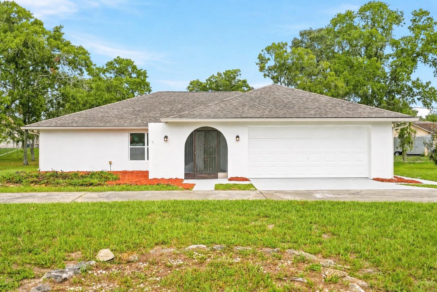 Welcome to this beautifully renovated 3-bedroom, 2-bathroom pool home situated on an oversized corner lot of more than half an acre. With a circular driveway, expansive front yard, 2-car garage, and covered screened front porch, this home offers plenty of space inside and out with fantastic curb appeal.Step inside to a light, bright, and completely refreshed interior featuring high vaulted ceilings, LVP flooring, abundant natural light, and an open floor plan designed for both everyday living and entertaining.At the heart of the home is the stunning fully renovated kitchen, complete with quartz countertops, a waterfall-edge island, soft-close cabinetry, all-new appliances, and a casual eating space. A separate dining area includes its own bar area with a beverage refrigerator, creating the perfect setup for entertaining. The living space is anchored by a functioning fireplace, adding warmth and character to the modern interior.The split-bedroom floor plan provides plenty of privacy, with a spacious primary suite featuring sliding glass doors that open directly to the screened pool area. The primary also offers a generous walk-in closet and beautifully renovated en suite bathroom. On the opposite side of the home, the guest bedrooms share a fully renovated bathroom featuring stylish double herringbone tile. Linen closets and additional storage spaces throughout the home provide plenty of room to stay organized.An interior laundry room comes complete with a brand-new washer and dryer, while ceiling fans throughout add everyday comfort. Outside, enjoy your own private Florida retreat with a screened-in pool and an incredible amount of yard space. With more than half an acre on a corner lot, there is plenty of room to enjoy the outdoors.Additional updates include a brand-new roof, completely renovated kitchen and bathrooms, new appliances, and new washer and dryer—making this home truly move-in ready.Located in the heart of Spring Hill, the home offers convenient access to shopping, dining, schools, medical facilities, and everyday necessities, with easy connections to major roadways for travel throughout Hernando County and the greater Tampa Bay area. Enjoy being within reach of some of the Nature Coast’s favorite outdoor destinations, including Weeki Wachee Springs, nearby parks and trails, and Gulf Coast recreation, while still coming home to a spacious property with plenty of room to spread out.
