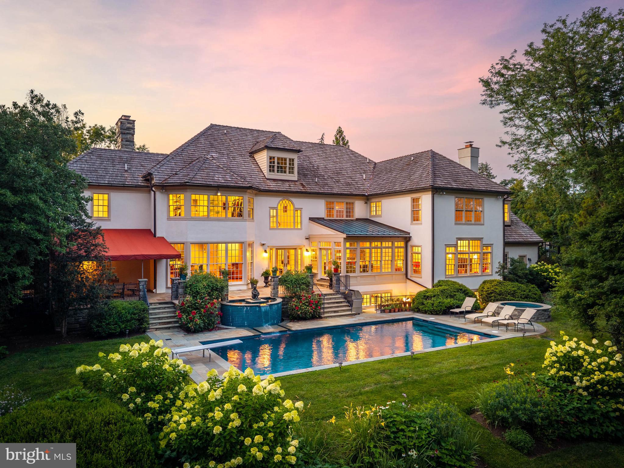 Pohlig-built stone manor home on Eagle Farm Road, in Villanova's estate section, filled with natural light in a way traditional construction rarely allows. The windows in the living and dining rooms were enlarged to floor-to-ceiling, their transoms removed. The rooms are genuinely large, and the whole first floor is organized around light, volume, and view. The home sits in an enclave of estate homes around a landscaped island, on 1.26 level, manicured acres framed by mature trees and specimen plantings.The living and dining rooms, in their heightened glass, offer sweeping views of the grounds. The kitchen anchors on a granite-topped center island and flows into a breakfast room set beneath a barrel-vaulted ceiling, where two walls of windows and French doors open to the flagstone terrace. The family room rises to a coffered ceiling — fireplace, a full run of custom cabinetry, and the same rear wall of glass. A first-floor study finished in wood, with a fireplace, built-ins, and windows on multiple exposures, opens to an awninged section of the flagstone terrace.Upstairs, the primary suite occupies its own wing: fireplace, private bath, an elevated dressing room of genuine scale, and an adjacent room offering flexibility — sitting room, second home office, nursery, or a dressing suite of its own. The secondary bedrooms fill the opposite wing, one a suite large enough to serve as a second primary. The hallway is finished with custom bookcases and built-in workstations, and a second-floor laundry completes the level. A rear staircase connects all three floors.The day lit lower level is built for recreation: a home theater with tiered seating, a billiards area, a wet bar with curved counter served by a wine cellar, and an exercise room with sauna and full bath. A staircase rises directly to the rear grounds and pool — so summer afternoons move between the pool, the sauna, and the bar without passing through the main rooms.Outside, flagstone terraces step down to a pool with a spillover fountain and a hot tub, surrounded by perennial gardens and layered plantings. Southern exposure keeps the terrace in use from spring through fall. Three-car garage. Lower Merion School District.And the math has changed: the Montgomery County Board of Assessment Appeals reduced this property's assessment by 26%, cutting real estate taxes from $75,000 to approximately $55,500 — $19,500 per year, effective with the 2027 tax year.Offered at $3,395,000. Open house Thursday, July 30, 1–3 PM. Private showings available by appointment.