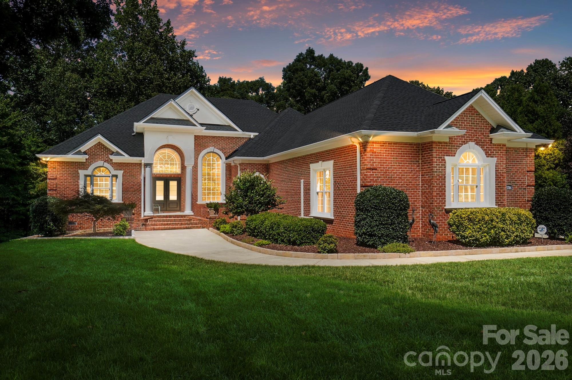Exceptional Lake Wylie property situated on approximately 1.2 acres, offering expansive seasonal Lake Wylie views, no HOA, and predominantly main-level living. Impeccably maintained, this all-brick home with stucco accents combines quality construction, space,  privacy, thoughtful updates, and beautifully appointed living spaces in a setting that is increasingly difficult to find.Inside, beautiful hardwood floors, extensive moldings and trim, soaring detailed ceilings, plantation shutters, and abundant natural light create an elegant yet comfortable setting. The completely redesigned chef’s kitchen is truly the centerpiece, featuring custom Dutch Made cabinetry, a massive contrasting island, natural quartzite countertops, Rocky Mountain solid bronze hardware, a 48-inch Wolf gas range with cooktop and griddle, microwave drawer, dual-zone wine cooler, custom storage and drawer organization, and extensive lighting with dimmers. The kitchen opens seamlessly to the family room, where a fireplace and walls of windows overlook the private wooded backyard and frame beautiful lake views.Three spacious bedrooms are located on the main level, each with its own full bath. The split-bedroom layout provides excellent privacy, with the oversized primary suite separated from the secondary bedrooms. The primary suite features a vaulted ceiling, custom walk-in closet, plantation shutters, and a spacious bath with separate vanities, tiled shower, and jetted tub. With hardwood floors throughout and no carpet, the main level offers comfortable one-floor living, while the upstairs bonus/flex room includes a full bath and custom built-ins, making it ideal for guests, recreation, office space, or additional living space. Septic permit is for three bedrooms.Outdoor living is equally impressive. The extended rear entertaining area includes an epoxied surface, covered space, integrated natural gas firepit, and gas grill hookup, all overlooking the exceptionally private wooded backyard. Additional outdoor features include a whole-yard irrigation system, deer-protected garden area, and beautiful sunrise views.The extensive list of improvements and features includes a new roof, whole-house natural gas Generac generator with automatic transfer switch, whole-house surge protector, crawlspace with dehumidifier, Rinnai tankless water heater, water filtration and UV light system, underground gutter drainage, central vacuum, whole-house speaker system, connectivity access points, and four exterior Arlo cameras (requires internet and subscription).The oversized three-car garage is climate controlled by a dedicated mini-split system and features epoxy flooring, insulated garage doors, extensive custom storage, and ample room for a full-size pickup truck. The spacious driveway provides easy turnaround and additional parking.Built with full-brick construction and 2x6 exterior walls, this home reflects a level of quality and attention to detail rarely found in today's market. Additional highlights include a Clark Hall custom wrought iron front door, custom built-ins, underground gutter drainage, continuous Orkin termite protection with annual inspections, and screens for all windows.Tucked away in a private Lake Wylie setting yet convenient to Belmont, Gastonia, Rock Hill, and Charlotte, the home is close to shopping, dining, groceries, healthcare, Charlotte Douglas International Airport, and Uptown Charlotte. Located in the award-winning Clover School District and currently zoned for the new Lake Wylie High School.Exceptionally clean, meticulously maintained, and truly move-in ready, this is a rare opportunity to enjoy acreage, privacy, lake views, extensive upgrades, quality construction, and no HOA in the Lake Wylie area.