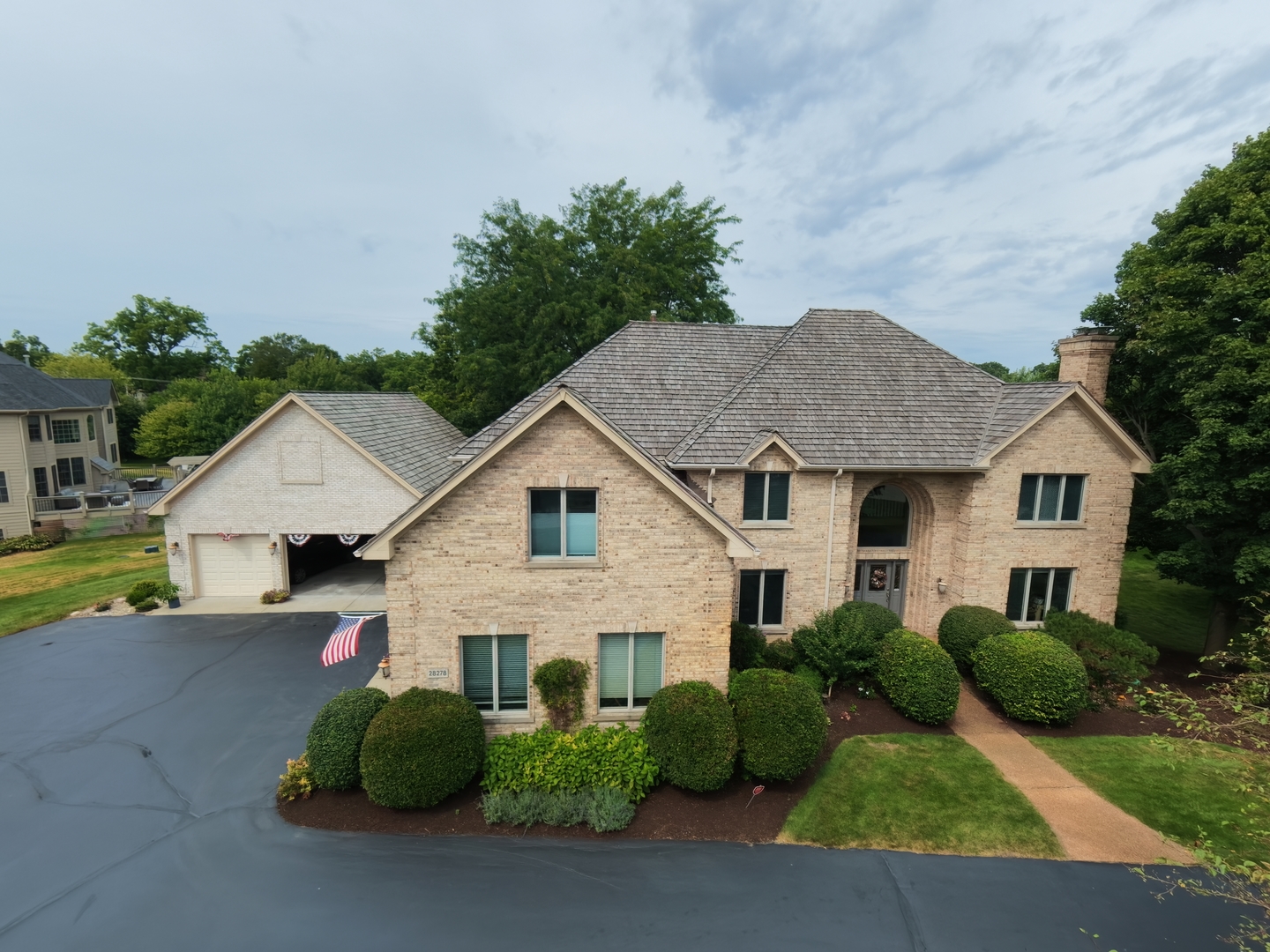 This exceptional Michael Graft-designed custom home showcases extraordinary craftsmanship, thoughtful design, and timeless architectural details throughout. Situated within a prestigious community in Lake Barrington,  this property offers a rare combination of distinction, functionality and pride of ownership. From the moment you arrive, the impressive architecture, beautiful brick exterior, mature landscaping and expansive private grounds make a lasting impression.  The welcoming interior features soaring ceilings, abundant natural light, beautiful hardwood floors, skylights, elegant millwork and spacious living and entertaining areas. The gourmet kitchen offers generous cabinetry, granite countertops, a large center island, and quality appliances, flowing seamlessly into the home's comfortable gathering spaces.  The luxurious primary suite features a spacious sitting area, creating a private retreat perfect for reading, relaxing, or enjoying quiet time. Generously sized additional bedrooms and four full and two half bathrooms provide comfort and convenience for family and guests.  The walkout basement level is an entertainer's dream, featuring a dedicated home theater, spacious gym, full bathroom and bar rough-in. With direct access to the outdoors, this versatile level offers an ideal setting for movie nights, fitness, entertaining, recreation or creating additional living space.  This meticulously maintained home offers an impressive list of recent improvements, including new premium heavy Cedar Shake Roof (2023), new gutters with lead guard, two new skylights, two A/C units and furnace (2020), newer water treatment system, refrigerator (2020), well pump (2024), sump pump with backup battery (2024), four newer radiant-floor heating pumps, garage door opener (2024), and new deck railings and posts (2025).  For the car enthusiast, collector, hobbyist, or anyone seeking extraordinary storage, this property is truly one of a kind. In addition to the massive oversized garage/workshop with approximately 22-foot ceilings and space to accommodate up to 10 vehicles, the home features additional attached 3-car garage.  With total capacity for up to 13 vehicles, the combined garage space provides an exceptional setup for equipment, hobbies, workshops, or the ultimate man cave-an incredibly rare offering in a premier residential neighborhood.  Step outside to enjoy the expansive deck and beautifully landscaped grounds, creating a private and inviting setting for entertaining, relaxing, and enjoying the surrounding natural beauty. Proudly own an exceptional home in an exclusive million-dollar neighborhood offering unmatched luxury, flexibility, and architectural character.