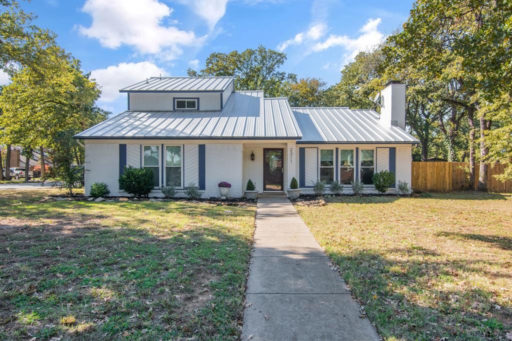 BEST AND FINAL OFFERS BY 6PM SATURDAY 17TH - This is a home with true personality. Set on a lush corner lot in highly sought-after Russwood Estates, this 3-bedroom, 2.5-bath residence blends established neighborhood charm with thoughtful modern updates.Mature trees and fresh exterior paint create standout curb appeal, while inside, vaulted ceilings, crown moulding, and abundant natural light set a warm, inviting tone. Throughout the home, stunning engineered hardwood flooring adds both elegance and durability—completely carpet-free, making it an ideal choice for those with allergies or a preference for low-maintenance living. The expansive living room anchors the space with a classic brick accent wall and cozy fireplace.The open-concept layout flows seamlessly into a stylish, functional kitchen designed for gathering, featuring an oversized custom island with generous storage, stainless steel appliances, crisp white cabinetry, and updated countertops and fixtures completed in 2022.The first-floor primary suite offers privacy and convenience with a full bath and two walk-in closets. Upstairs, a versatile loft provides flexible living space ideal for a home office, second living area, or playroom, along with two additional bedrooms and a full bath. Even the garage has been thoughtfully upgraded with epoxy flooring and a built-in workbench.Step outside to a large fenced backyard and unwind on the flagstone patio. The location is hard to beat—just minutes from Grapevine Lake, the marina and boat ramps, nearby parks, bike trails, and lakeside dining.Major updates provide peace of mind, including a metal roof installed in 2022, a new AC unit in 2023, interior paint and engineered hardwood flooring completed in 2022, and access to a top-rated school district.A rare opportunity to own a home with character, modern updates, and an exceptional lakeside lifestyle.