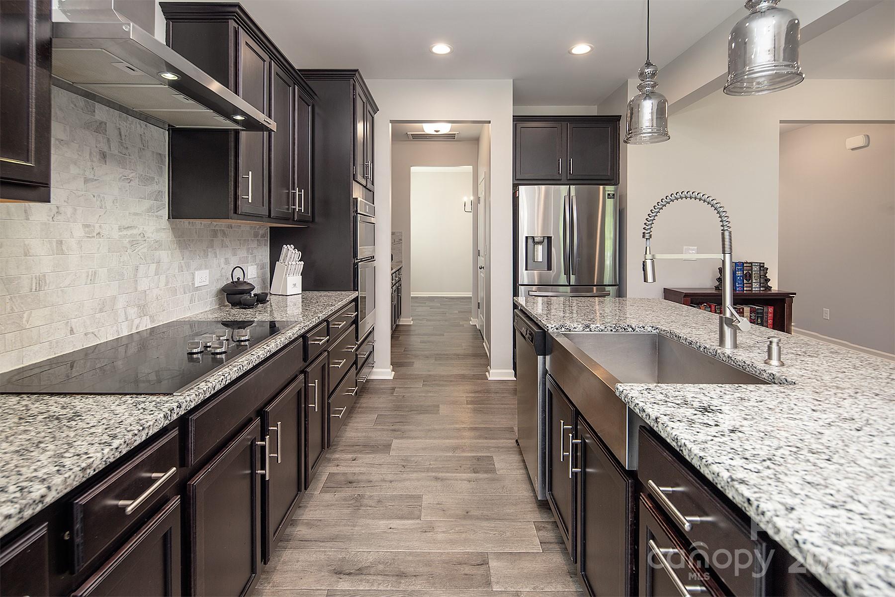 Welcome to Tillery Tradition! This beautiful 2019-built 2-story Wakefield model by TruHomes offers 5 bedrooms, a bonus/game room, and 3.5 baths. The main level features a spacious primary suite, office, mudroom, dining room, and a kitchen with granite countertops, a large island with farm sink, stainless steel appliances, and a butler’s pantry. The open living room includes a wood-burning fireplace. The primary bath offers a soaking tub, updated tile shower with dual heads, and dual vanities. Upstairs boasts 4 bedrooms, an awesome bonus room, and a Jack-and-Jill bath. Sitting on one of the largest lots in the community, this home backs to the golf course! Offering $1,500 buyer concessions! Assumable mortgage is available at 5.99% interest rate!