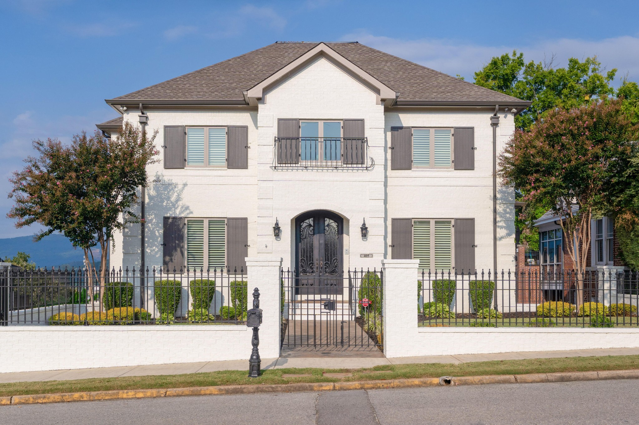 Located in the heart of North Chattanooga with fantastic views, this custom all brick home was built by Waldrep Construction in 2016 and boasts premium finishes, a great layout including an open floor plan, the primary suite plus a guest bedroom on the main, an in-law suite on the lower level, plus an oversized double garage and a single garage with extra storage and a workshop space - a rare find in this area. No detail has been overlooked, and you will love the beautiful moldings, tall ceilings and doors, hardwoods and tile, plantation shutters, recessed and decorative lighting, casement windows, custom cabinetry and closet systems, amazing storage and more. You will also love that there is an elevator servicing all 3 levels, the front yard is beautifully landscaped and fenced, and the rear parking pad and access to the garages is gated. Your tour of this 5 bedroom, 5 bath home begins with the lovely two-story foyer with dramatic metal and glass double doors. The formal dining room is to the left and has access to the kitchen via a hallway with the laundry room on one side and a walk-in pantry on the other. The kitchen is open to the breakfast area and the great room and has a center island with pendant lighting, granite countertops, tile backsplash, under-cabinet lighting, soft close and pull-out drawers, and a 5-burner gas cooktop and convection double wall ovens. The breakfast area has a fanciful light fixture and a built-in desk with cabinetry. The great room is the heart of the home with its generous size, gas fireplace and 2 sets of French doors to the covered balcony allowing for wonderful natural lighting and taking full advantage of the views. The primary bedroom is also on the rear side of the house and has access to the balcony, as well as the primary bath with a dual vanity, a walk-in closet, 2 linen closets and an arched doorway to the free-standing tub, separate shower with both rain and regular shower heads and a water closet.