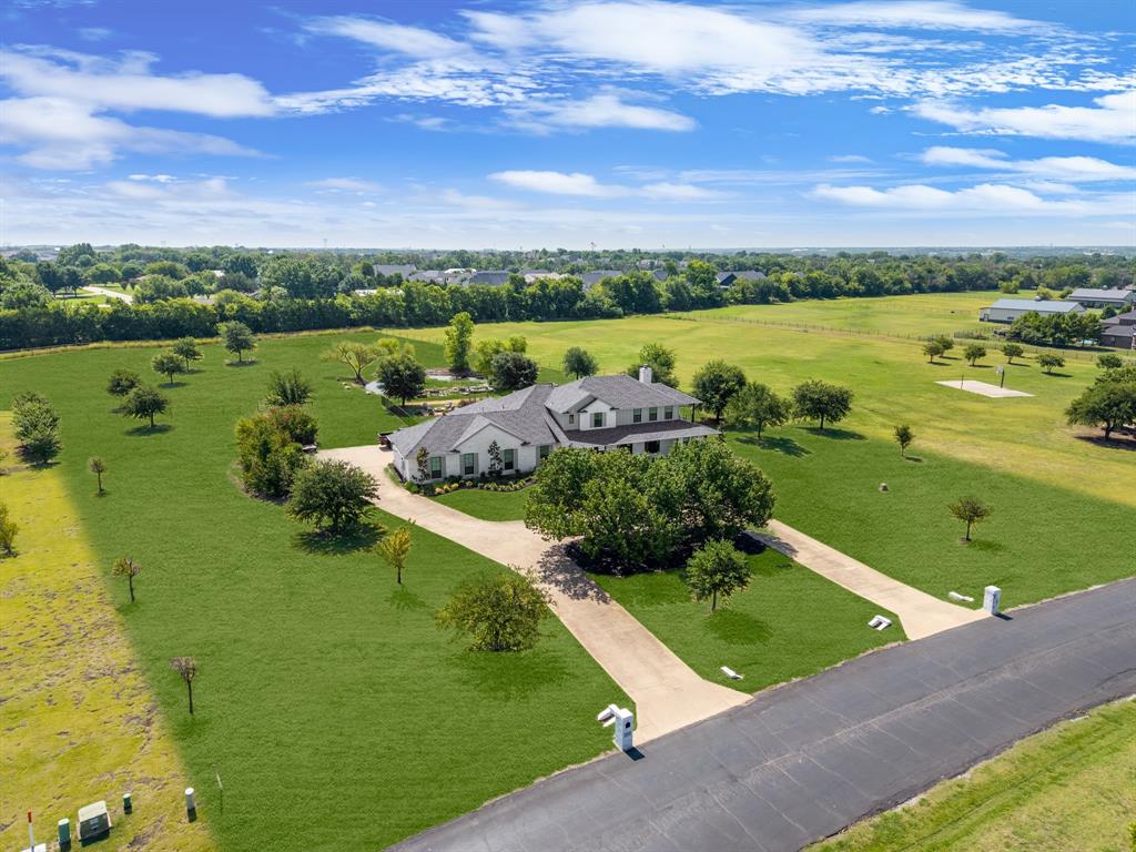 Amberwood Farms — a rare opportunity to own in Prosper’s premier gated acreage community, featuring just over 40 exclusive homesites on 3–6 acre lots. This completely remodeled modern farmhouse is nestled on a private 4-acre homesite in the Town of Prosper and zoned to award-winning Prosper ISD, offering luxury, privacy, and wide-open Texas living.A grand entry with new iron double doors opens to a bright, inviting layout designed for effortless everyday living and entertaining. The gourmet kitchen showcases an oversized eat-in quartz island, custom cabinetry, designer hand-laid tile backsplash, walk-through pantry, designer-series refrigerator, double ovens, and an apron-front stainless sink. Warm hardwood flooring, designer lighting, and large windows fill the open living and dining areas with natural light while framing expansive views of the surrounding acreage.The privately situated primary suite features a spa-inspired bath with dual vanities, freestanding soaking tub, marble finishes, and a frameless shower with three shower heads. A dedicated study or planning center, spacious secondary bedrooms, and an oversized upstairs bedroom with private bath and balcony offer flexible living options, including multi-generational use. The large upstairs game room provides additional space to gather, relax, and play.Outside, enjoy your own personal resort: sparkling pool, expansive patio, multiple lounging areas, and a fire pit perfect for sunsets and stargazing. With ample room for future additions such as a barn, sports court, or garden, this property delivers both luxury living and endless possibilities — welcome home to Amberwood Farms.***MAKE SURE TO CHECK OUT THE VIDEO UNDER LINKS***