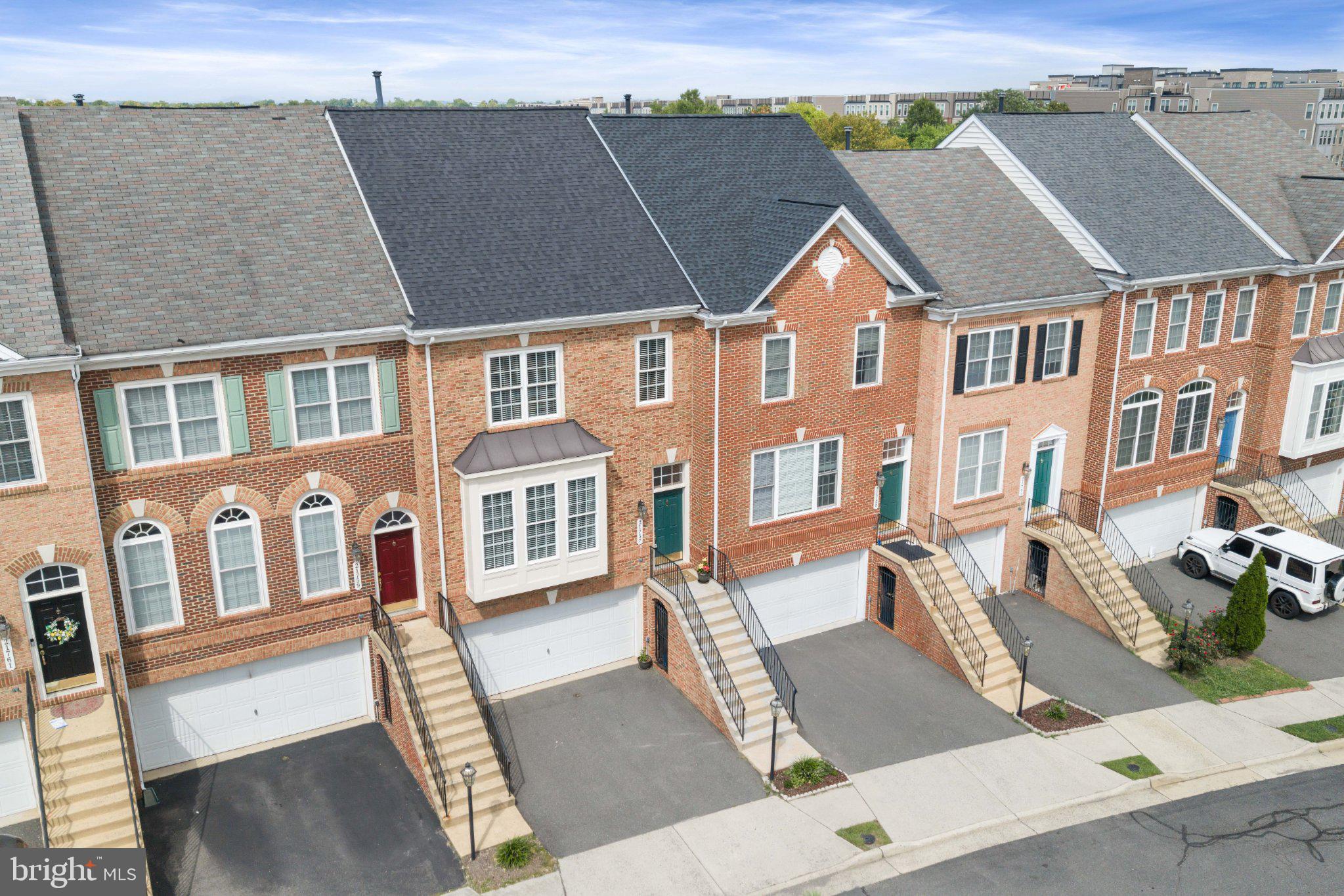Discover refined three-level living in this elegant brick-front townhome, ideally situated in Ashburn’s sought-after Faulkner’s Landing community. Offering three bedrooms, three full and one half bathrooms, a two-car garage, and additional driveway parking, this beautifully appointed residence delivers an exceptional blend of style, space, and convenience.Sunlight fills the sophisticated main level, where rich hardwood flooring flows through the gracious living and dining rooms. The well-designed kitchen features granite countertops, stainless steel appliances, a generous breakfast bar, abundant cabinetry, and timeless tile flooring. Open to the light-filled breakfast room, the kitchen extends effortlessly to the rear deck—an inviting setting for morning coffee, alfresco dining, and evening entertaining. Recent upgrades include a 2025 gas stove, microwave, and dishwasher, complemented by a 2021 refrigerator.The upper level is anchored by a serene primary retreat with plush carpeting and a spacious en-suite bathroom featuring a corner soaking tub, separate walk-in shower, and double-sink vanity. Two additional bedrooms offer plush carpeting and comfortable accommodations for family, guests, or a private home office. A bedroom-level laundry area with a 2021 washer and dryer adds everyday ease.Designed for both relaxation and entertaining, the walkout lower level features an inviting family room centered around a gas fireplace, a full bathroom, and direct access to the rear patio. Beyond, the fully fenced backyard offers a private outdoor escape complete with custom-built raised garden beds.Significant improvements provide added confidence, including a roof replacement and new Lennox furnace in 2024, as well as an air-conditioning system installed in 2017. Both roof and furnace have transferrable warranties.Faulkner’s Landing places you near neighborhood walking paths, the Ashburn Silver Line Metro station, and the vibrant dining, shopping, movies, and entertainment of Loudoun Station. With the Dulles Greenway less than a mile away, Route 28 less than five miles away, and Dulles International Airport approximately eight miles from home, this exceptional property pairs polished interiors with effortless access to the best of Northern Virginia.