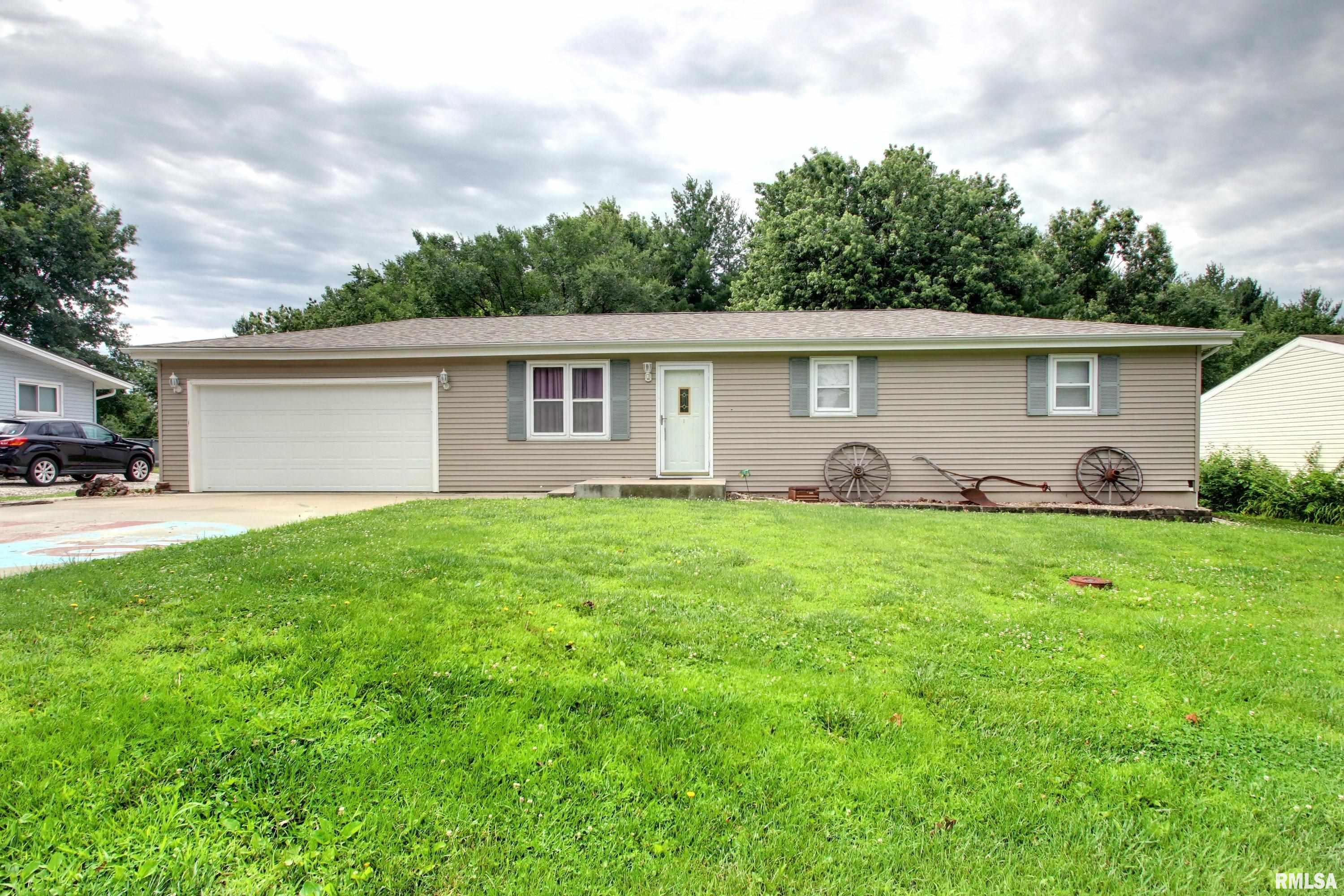 Welcome home to this darling 3 bedroom, 2 bath ranch tucked into the quiet small town of Mendon, Illinois. The open floor plan creates an easy, airy flow perfect for everyday living and entertaining alike. The kitchen shines with new stainless steel refrigerator, and the full, finished basement adds impressive living space with a comfortable family room, a full bath, and a flex room currently used as a bedroom (no egress) perfect as a home office, playroom, or guest space. A new roof (2025) means peace of mind for years to come.   Step out back to a large deck, ideal for grilling and gathering, overlooking a tree-lined, fenced yard that offers privacy and shade. An attached two-car garage rounds out this low maintenance home in a wonderful small town setting. Sellers are offering a $3,000 flooring allowance with an acceptable offer so bring your vision and make it your own!
