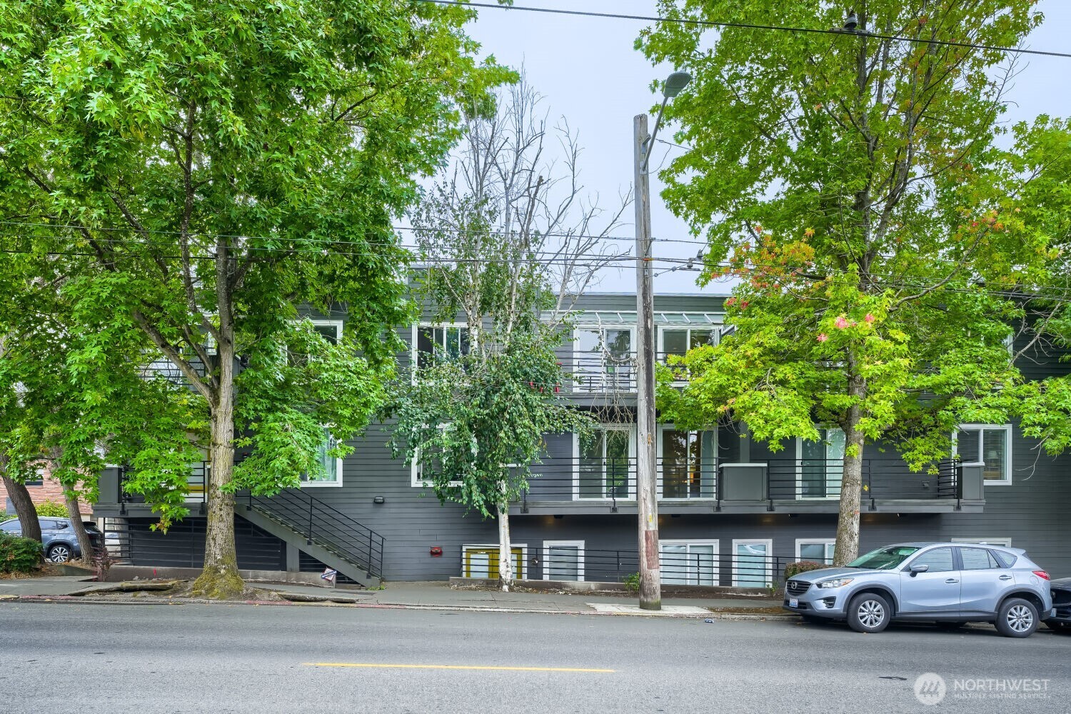 Rare opportunity on top of Queen Anne Hill. This recently updated condo lives like a two-level townhouse. 901 sf with 2 bedrooms and 1.5 baths over 2 levels. The open floorplan features ample windows and skylights that bathe the unit in natural light. The Main level offers kitchen, living, dining, an office nook, and a half bath, plus a private and spacious deck with territorial views to the north. Downstairs you’ll find two bedrooms, a second deck, laundry and a full bathroom with combo shower / soaker tub. Primary bedroom features a spacious walk-in closet and access to the 2nd deck space. Recent updates include brand-new paint throughout and carpet on the stairs and lower levels. The secure garage includes one dedicated parking space (#14), and a spacious storage unit. Exceptional location with transit, gyms, restaurants, coffee shops, parks, shopping, and nightlife all within a short stroll. Unbelievable walk-score of 95. This top-floor, townhouse-style home offers a tranquil retreat away from the bustle of Queen Anne Avenue just 1.5 blocks away. No pet restrictions.
