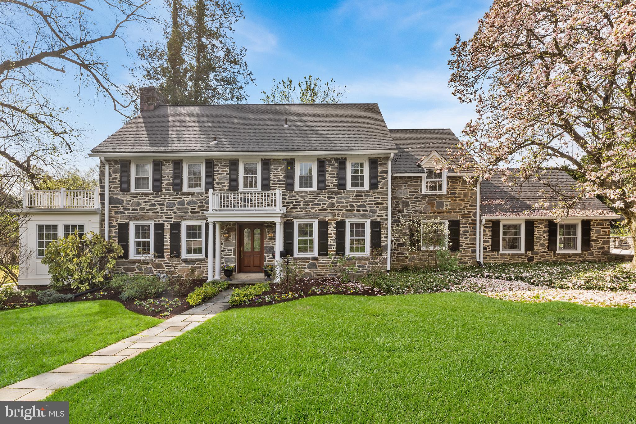 A rare offering in the heart of Bala Cynwyd, where 1930 stone colonial craftsmanship meets abeautifully curated modern interior on one of the neighborhood's most coveted corner lots. Set behindstately rod iron fencing, this magnificent residence offers historic character, flexible modern living,and an address in the award-winning Lower Merion School District. Pass through the iron gate andfollow the walkway to one of the most memorable front doors in the neighborhood. Step into awelcoming foyer where the home's exceptional layout immediately reveals itself. To the left, a graciousformal living room anchored by a wood-burning fireplace flows into a sun-drenched home office andstudy addition, wrapped in two walls of oversized windows that pour in natural light, ideal for today'swork-from-home lifestyle. To the right, a formal dining room impresses with built-in cabinetry,generous window sills, and a stunning chandelier casting the room in warm, elegant light. Stepthrough the swing door into the heart of the home: a large eat-in kitchen refreshed for 2026 withCalacatta Miraggio Gold quartz countertops, crisp white tile backsplash, new cooktop, and anundermount sink framed by a picture window overlooking the front yard. The open-concept flowcontinues into a dramatic great room with soaring ceilings, a second fireplace, and flanking built-insthat deliver both grandeur and everyday function. French doors open to a private side patio wrapped ina stunning stone surround, a true outdoor space perfect for al fresco entertaining. A large laundryroom and powder room complete the first floor. Upstairs, the center staircase leads to an idealbedroom layout. The primary suite offers a generous closet and a spa-inspired ensuite, soaking tub, and separate shower. Three additional large bedrooms share a well-appointed hallbathroom, each offering scale and proportion rarely found in newer construction. A secondarystaircase leads to the finished attic, a versatile flex space functioning beautifully as a fifth bedroom,playroom, or studio, with an additional bathroom and closet. The finished basement provides space fora media room, home gym, or recreation area, connecting directly to the attached garage with EVcharger. A French drain system and abundant storage make this lower level as practical as it is livable.Freshly painted throughout, new light fixtures, and updated in all the right places while honoring thesoul of its 1930 origins, 86 E Princeton Road is Bala Cynwyd Main Line living at its finest. Walk to shops,restaurants, and the Cynwyd Heritage Trail.