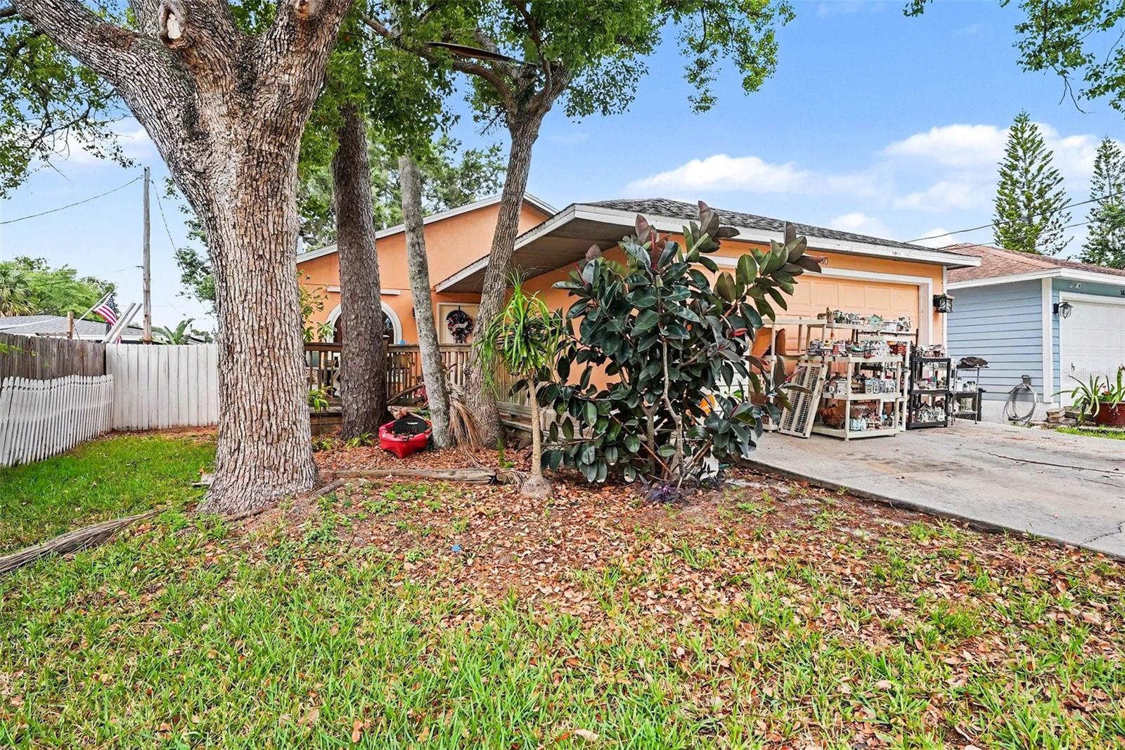 Come check out this Pinellas Park gem, ideally located close to local dining and shopping! From the inviting front deck and covered walkway, you are welcomed into a bright main living area featuring lofty vaulted ceilings, brilliant skylights, and a cozy fireplace. The great layout effortlessly flows into the dining nook and kitchen, perfectly separating the bedrooms. Two comfortable bedrooms and a full bath sit off the living area, while the primary suite boasts a walk-in closet and en suite bath privately located off the kitchen.The real showstopper is the private backyard outdoor living space. Step into a fully under-roof, screened-in back patio with a vaulted beamed ceiling, large fan, warm wood paneling, and an already-installed hot tub that will transport you to another world. Just beyond is an open-air grilling and sun deck leading to a spacious, fully fenced backyard. Complete with two utility storage sheds and gated alley access, this yard offers the perfect opportunity to add an ADU or mother-in-law suite.Bonus features include an insulated garage conversion ready for your ideas, a 2017 hurricane window upgrade, and a brand-new range. The home is move-in ready with room to customize, so bring your design dreams and make this private retreat your own!