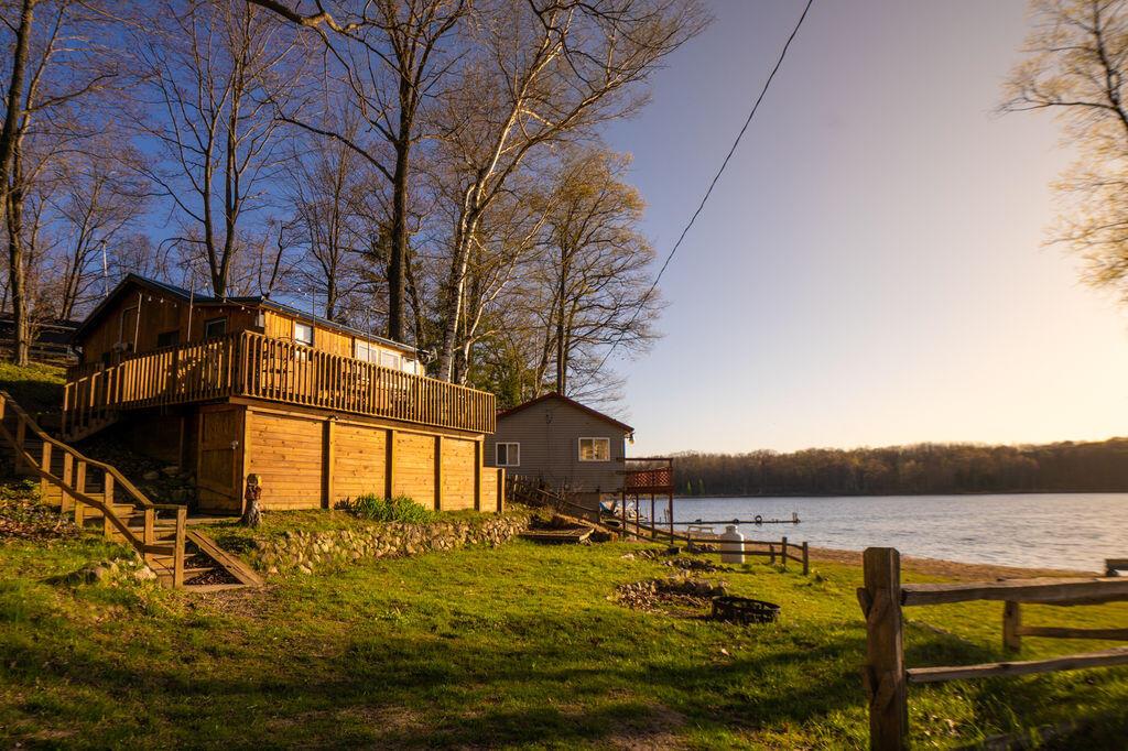 Cozy Lakefront Cottage on Bluff Lake -escape  to this fully renovated, fully furnished lakefront cottage on serene Bluff Lake--ideal as a cozy retreat or lucrative Airbnb. Stylish shiplap and knotty pine accents complement an open-concept layout with a modern kitchen, cozy bedroom, and updated bathrooms. Enjoy a large deck and new dock for lakefront living. Brand new: roof, gutters (with leaf guard), kitchen cabinets, counters, sinks, faucets, flooring, appliances (except fridge), plumbing, electrical, tankless water heater, water softener. Move-in ready for relaxation or rental income! The basement could be finished for additional living space.