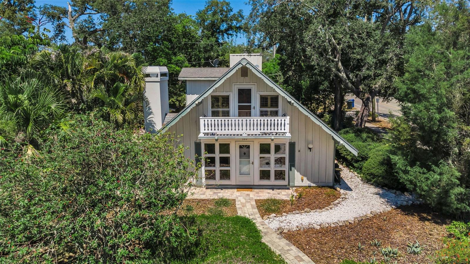 Under contract-accepting backup offers. An absolutely charming home nestled on a fenced, corner lot is the perfect example of a rare and unique architectural nuance found in what is lovingly called “Delightful Dunedin”.  Amidst the natural beauty of this amenity-rich town, you’ll find this inviting 2-story/3 bedroom/2 bath with garage home. The sun-filled living room is spacious and boasts a dozen front-facing windows accompanied by a brick-faced, wood burning fireplace and hickory colored hardwood flooring. The adjacent dining room also reflects the natural light while the kitchen offers a rustic ambiance juxtaposed against stainless steel appliances, ample cabinetry, built-in spice rack, and generous pantry. The first-floor bedroom is wonderfully appointed with glass French doors revealing a private patio, making this space an ideal suite to accommodate a returning grad! Its accompanying bath features both a tub and shower, along with refined stylings. Upstairs, an expansive den can serve a multitude of purposes: playroom, home theater, or yoga studio with vaulted ceilings that lend drama to this exceptional space. Magnificent cathedral ceilings make a bold statement in the master suite crowned with skylights and made even homier with its own wood-burning fireplace flanked by more windows. The ensuite showcases a tiled shower room. The second upstairs bedroom is also light and bright with access to a lovely balcony overlooking the tranquil neighborhood. Beautiful pavers unify the large outdoor space and combine to create two individual pathways around the perimeter. A stone fire pit will be your new destination to relax and entertain. Besides a home security system, there’s a sprinkler system that uses reclaimed water. Additional room adjacent to the garage has A/C, perfect for work out room, office space, or an art studio complete with additional shower and a closet for storage. . A stunning waterfront town, Dunedin is known for the array of distinctive shops, eateries, and for hosting seasonal celebrations. Colonial Court’s cozy neighborhood is just minutes from Edgewater Drive Park on the Dunedin Channel, Dunedin Blue Jays’ stadium, Dunedin Fine Arts Center, and the Pinellas Trail -- the famous 47 mile venue that spans from Tarpon Springs to St. Pete welcoming joggers, skaters, cyclists, and anyone who wants to enjoy a scenic stroll!