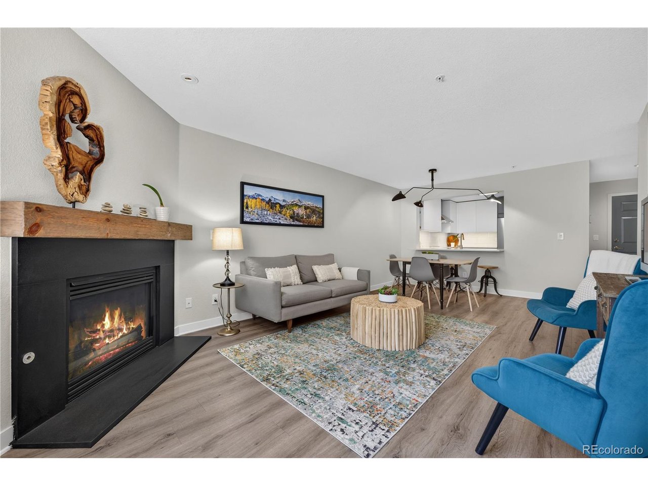 The most updated unit within Rocky Mtn Village, Evergreen's most accessible 55+ community. This perfectly located ground-floor home provides barrier-free access (via the association sidewalk) to nature & open space, plus all the neighborhood amenities & conveniences of Bergen Park - King Soopers, Starbucks, restaurants, trails, parks, hair & nail services, banks, bakeries, Center for the Arts Evergreen, places of worship, transit, and more. A private carport plus open surface parking are included, yet many people see no need for a car upon arriving at Rocky Mtn Village due to the amenities & transit options available within the building & nearby. On site is a gym, library, woodshop, hobby room, one bedroom guest suite, community room with a kitchen, large dining area, and great room with a fireplace & grand piano. Intelligently designed, unit 115 gives you everything you need & nothing you don't. Enjoy a spotless kitchen with top-notch KitchenAid appliances, pristine quartz countertops, undercabinet task lighting, oversized cabinets, floating shelves, generously sized breakfast bar, and pantry. A gas fireplace, stone surround & custom mantel anchor the open concept living & dining area, which flows directly out to the private patio & HOA open space with a picnic area. This green space is your view from every window, and is a daily haven for wildlife year-round. The king-size primary suite features a walk-in closet with stacked laundry & custom organizers, plus an ensuite bath with a soaking tub, dual vanity, medicine cabinets & linen closet. Across from the spacious, mobility-minded second bathroom with a custom shower, accessible sink area & additional built-in storage is a queen-size guest room - or flex this room as an office with space for bunks or a Murphy bed. For added peace of mind, in-floor radiant heat (included in HOA dues), durable LVP flooring, and fresh paint relieve your maintenance worries. This is your spot to age in place, in nature, and in style.