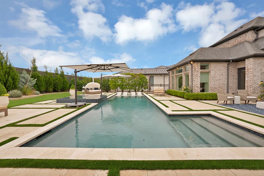 Located within the prestigious gated community, The Hills of Kingswood, this extraordinary five bedrooms, seven baths estate redefines modern luxury through impeccable craftsmanship, grand scale entertaining spaces, and a resort caliber outdoor retreat. Every detail of this remarkable residence has been thoughtfully curated to deliver an elevated lifestyle marked by sophistication, privacy, and timeless elegance.From the moment you enter, the home makes an unforgettable impression with soaring ceilings, designer lighting, and expansive walls of glass windows that flood the interiors with  natural light. The grand living room serves as the centerpiece of the home, offering a stunning blend of warmth with its statement fireplace, expansive open layout, and seamless connection to outdoor living spaces. Each of the five oversized bedrooms serve as a private retreat complete with ensuite bathrooms and custom walk in closets, delivering unparalleled comfort and privacy. The luxurious primary suite offers a tranquil escape with a large boutique style closet, soaking tub, and an oversized spa inspired steam shower.The resort inspired backyard is truly spectacular. Anchored by a stunning custom pool with dramatic water features, ambient lighting, and expansive sun lounges. Multiple entertaining spaces are surrounded by lush manicured landscaping. The covered patio serves as a seamless extension of the home and features a fully equipped outdoor kitchen also included automated shutters, heaters, and mosquito mist system allowing for a spacious gathering area designed for elevated entertaining to enjoy all year-round.For the automotive enthusiast, the impressive four car garage is elevated with two premium vehicle lifts accommodating up to six covered vehicles. Complete with showroom quality epoxy floors, custom lighting, and ample space for collectibles or recreational vehicles, the garage doubles as the ultimate luxury showroom and entertainment space.