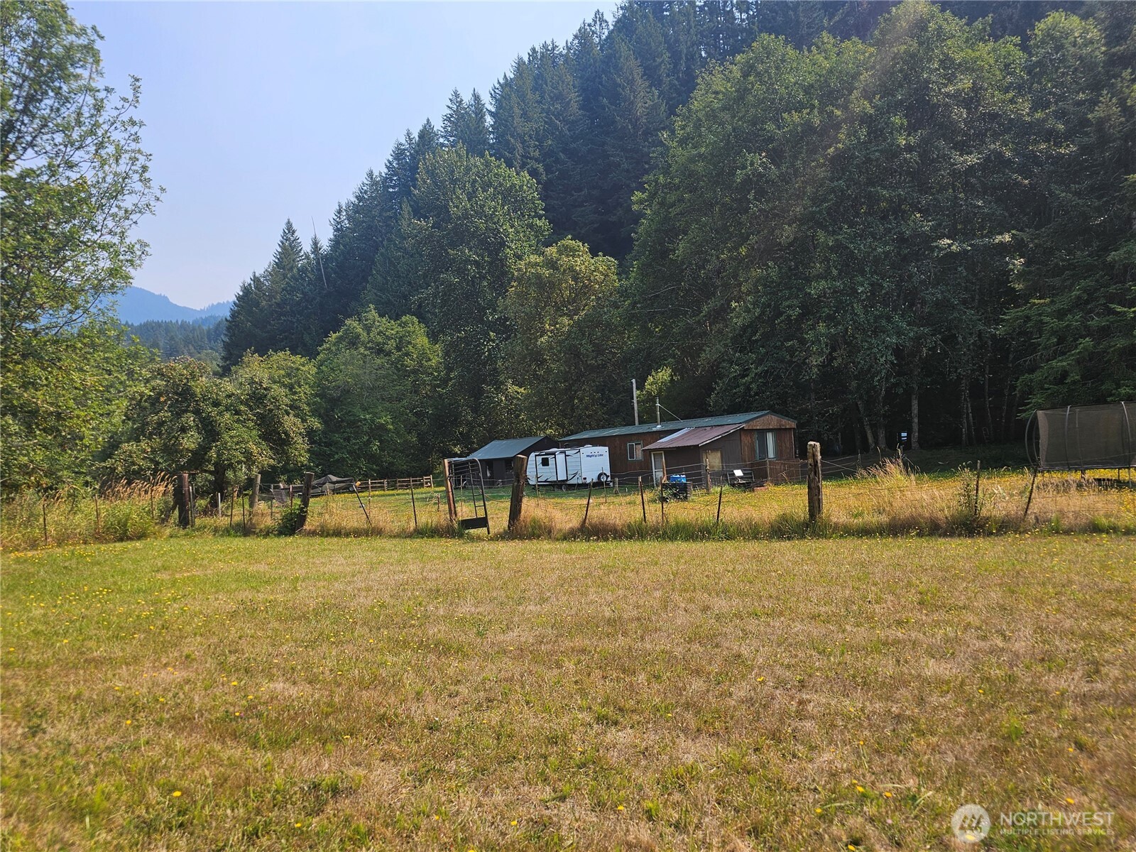 Bring your animals, your dreams, and your sense of adventure! Tucked into a peaceful valley in the Cascade foothills, this 2-bedroom home sits on 2.48 acres with fenced pasture and plenty of room to create your own country retreat. Property features include a 24x20 barn, round pen, chicken coop, 16x18 carport, and two newer 10x10 and 10x20 outbuildings offering excellent storage, workshop, or hobby space. A cozy wood stove adds warmth and rustic charm, while the home offers an opportunity to add your own touches and make it truly yours. Enjoy the best of Pacific Northwest living, with lakes, hiking, fishing, and hunting nearby, plus easy access to Packwood and White Pass Ski Area. Whether you're looking for a mini-farm, recreational getaway or peaceful place to call home, this property offers space, privacy, and possibilities!