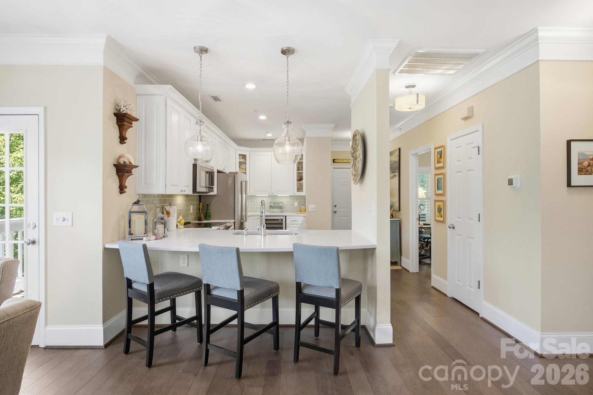 An absolute peaceful, serene retreat, feels like a treehouse.  On the top floor with covered porches surrounding this very special condo, views of all natural areas and pond and no shared walls.  This 2 Bedroom, 2 Bath Condo with 1 1/2 car garage, located perfectly & conveniently in the heart of Cornelius! A spacious, open floor plan with great natural light! Fresh paint throughout! Wide plank real hardwood maple floors throughout, crown molding in all main living areas and 7 1/2 inch height floor boards.  Marble tiles in both baths, all new cabinetry throughout with soft close doors and drawers. Large Kitchen with all Kitchen Aid stainless steel appliances, Monogram wine cooler, glass tile back splash, plenty of cabinetry for storage, recessed lights, breakfast bar & pantry! Great Room with easy access to your expansive, covered deck to relax & unwind, while enjoying the mature landscaping & trees surrounding you! Spacious Primary Bedroom with sliding doors to outdoor deck, ceiling fan, private bath & walk in closet with elfa closet systems in both primary and second bedroom closet. Two columns of drawers in primary closet and one column of drawers in second bedroom closet! Primary Bath offers dual vanity, tiled shower & tile floors with frameless glass shower wall and door.  All updated lighting, plumbing fixtures and hardware, this condo has been fully updated and upgraded.  Edinburgh Square is a coveted, established community featuring a pool, club house, several greenway entry points & is located close to restaurants, shopping, entertainment, Jetton Park, Lake Norman & Birkdale Village!