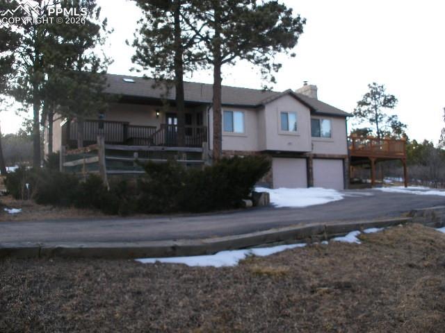 Home features .95 acres in the highly desirable Woodmoor Subdivision. It offers  an easy commute to Colorado Springs or Denver but yet the home sits in a nice quiet area. There is a fully paved turn-around type driveway with plenty of parking plus the two car attached garage. The main level has a remodeled primary bedroom and remodeled en-suite bathroom. Also, on the main level are two additional bedrooms and a full bath. An open floor plan with vaulted ceilings and exposed wood beams.  A gorgeous fireplace is also on this level.. The fireplace and walk-out is attached to the great room, eating area, and kitchen. Updated kitchen with granite counters and large island. Downstairs is an open rec room, another bedroom and full bath. A stairway chair lift between floors.  In total there are 3  decks from the the home, one is walkout from the great room /dining room area and another one from the master bedroom. There is mature pine trees, a flagstone patio, fire pit and more.
