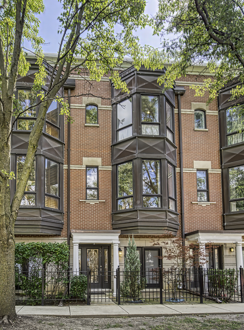 In a quiet, tucked-away pocket of Old Town, this sunlit townhome combines a neighborhood feel with the convenience of city living. This home offers 3 bedrooms, 3.5 baths, and an attached two-car garage with epoxy floor, along with a flexible layout designed to fit your needs. The main level features a homey and inviting living and dining area with high ceilings, a fireplace and a beautifully updated kitchen with cherry cabinetry, granite countertops, stainless steel appliances (including a brand new Thermador oven!) and a balcony for grilling or morning coffee. Upstairs, the primary suite includes a walk-in closet and recently renovated bath with heated floors and a luxury double shower. The sunny second bedroom also has an en suite bathroom. The top level is an entertainer's dream with a wet bar, doors to a rooftop deck with skyline views, and space that can serve as a family room, office, or even a fourth bedroom. Four outdoor spaces-rooftop deck, kitchen balcony, front patio, and courtyard-provide room to enjoy the outdoors in every season. With custom closet organizers, generous storage, guest parking, and a location steps from Wells Street dining, shopping, and everyday conveniences, this home has so much to offer! NEWER FURNACE, AC AND WATER HEATER!