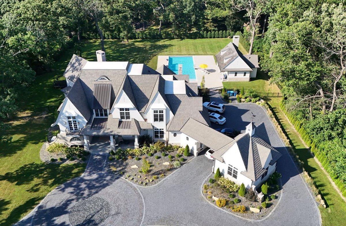 Welcome to what may be the most extraordinary private estate ever offered in the Southwest Suburbs. Set on approximately 2 acres surrounded by mature forest, this magnificent estate delivers a combination of architectural grandeur, resort-style living, unparalleled amenities and exceptional infrastructure. Every element has been thoughtfully designed and built using only the finest materials. From the moment you arrive through the gated entrance, an expansive, artistically designed brick drive unfolds through dramatic lighting and intricate custom inlays, culminating in a spectacular circle drive. The residence offers approximately 11,000 square feet, 7 1/2 bathrooms and 6 bedrooms with an additional 3 flex rooms. Car enthusiast's dream with a porte-cochere and an extraordinary 8-car garage, including a garage bay equipped with lifts. Inside, grandeur begins in the impressive foyer, where soaring architecture and meticulous craftsmanship immediately establish the caliber of this remarkable home. DaVinci Roof, copper gutters, 8-foot interior doors, five fireplaces, custom architectural details, radiant heat and extraordinary finishes continue throughout. The formal dining room features a dramatic decorative ceiling, while the gourmet kitchen is complemented by a private butler's pantry and designed for both grand-scale entertaining and intimate everyday living. A beautifully appointed mudroom offers individual closets, while the dedicated office features custom built-ins and its own balcony. Upper level bedrooms all complete with their own built-in furniture and ensuites. Elevated primary with gorgeous decorative ceiling that includes 2 chandeliers and adjoining balconies. Spa inspired bath unlike any you've seen or even imagined. Dual under-lit vanities. Private commode tiled floor to ceiling, and spectacular bubble tub! The home's expansive living spaces flow effortlessly between sophisticated interiors and spectacular outdoor environments. The backyard rivals the finest private resorts. At its centerpiece is an extraordinary 25' x 60' saltwater swimming pool, complete with an electric pool cover, artistic fire features, dramatic water elements and two distinctive fire-art installations. The pool is surrounded by expansive paver terraces designed for effortless unforgettable summer evenings. The spectacular pool house elevates outdoor living to an entirely different level, featuring: full bathroom, dedicated laundry room, fireplace, and locker/changing area. Expansive sliding glass doors offer direct access to the concrete pool surround.  Nearby, a covered outdoor bar and kitchen create the perfect setting for entertaining on any scale. Built-in grill, dishwasher and extensive storage, allowing the entire backyard to function as a sophisticated extension of the home. An additional outdoor fireplace anchors the paver patio, while dramatic lighting, fire baskets and artistic water features transform the property after sunset into an unforgettable private retreat.  And then there is the view from the above primary suite balcony. It is a fully realized private estate, meticulously crafted over two years with an extraordinary level of investment, attention to detail and uncompromising standards. From the gated entrance and spectacular illuminated paver drive to the eight-car garage, from the grand foyer to the private theater, from the primary suite balcony to the magnificent resort-style pool and pool house, every element has been designed to make an impression. Priced far below the seller's cost, this is an exceptional opportunity to acquire a truly one-of-a-kind luxury estate at a level of quality, scale and amenity rarely found anywhere in the Chicago area. Mechanicals include 600-amp electrical service, whole-house generator, public sewer and water with a private well dedicated to irrigation/sprinkler use. For the buyer who refuses to settle for ordinary, this is the property that defines extraordinary. It's a must see!!
