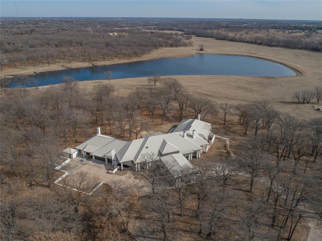 Discover an extraordinary estate in Norman, offering unparalleled luxury and tranquility. This 12,800 sq. ft. architectural masterpiece is nestled on 16.8 private acres, featuring a gated entrance, access to a 12-acre stocked pond, and breathtaking natural surroundings. Step inside to experience three levels of sophisticated living, where elegance meets comfort. The grand living room is a showstopper, complete with a serene koi pond, soaring ceilings, and an inviting ambiance. With four fireplaces, this home exudes warmth and charm. The gourmet kitchen and expansive dining areas make entertaining effortless, while the Saltillo-tiled game room, upstairs loft, and spacious office provide versatile living spaces. Retreat to the primary suite, a luxurious haven with spa-like amenities. Each of the four bedrooms offers en-suite convenience, complemented by an additional four half baths. Relax in the private sauna, enjoy the convenience of a large laundry room, and host guests in the separate guest quarters. The three-car garage provides ample space for vehicles and storage. Whether you're enjoying the tranquil pond views, exploring the vast acreage, or unwinding by one of the fireplaces, this estate is a rare find. Plus, the seller is offering $250,000 in concessions toward upgrade costs, making this an incredible opportunity to customize and enhance this exceptional property. Schedule your private tour today!