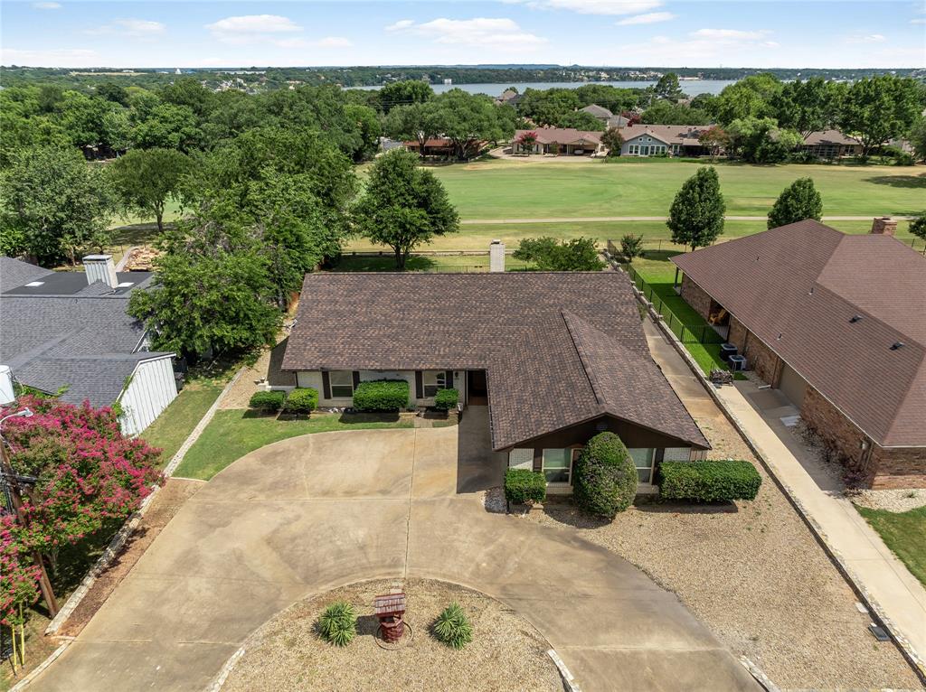 Welcome to your personal slice of golf paradise in the prestigious, 24-7 guard-gated community of DeCordova Bend Estates! This charming 3-bedroom, 2-bath home serves up unbeatable curb appeal the moment you arrive—and the perks only get better from there. Golf enthusiasts, this one's for you. With a dedicated golf cart garage and direct cart path access, you're just a quick ride from hopping on at the 14th tee box. Guests? They'll love the convenient circle drive parking when they come to visit. Step inside and discover a clean, thoughtfully designed layout full of character. The living room stuns with a wood-beamed vaulted ceiling, a cozy fireplace, and expansive picture windows framing serene golf course views. The space flows effortlessly into the dining area and kitchen—ideal for entertaining or quiet nights in. Craving more? Wander into the oversized sunroom where the views get even better, or take the party outside to the covered porch—the perfect shaded spot for spectating, sipping, and soaking it all in. The primary suite is your private retreat: spacious, sunlit, and blessed with gorgeous views. The ensuite bath features dual closets and dual sinks—because elbow room matters. Out back, a fully fenced yard offers privacy and space for pets, play, or peaceful mornings with coffee in hand. And the roof? Less than three years young—so peace of mind comes standard. All of this inside DCBE, where resort-style living is the everyday norm. Enjoy golf, tennis, pickleball, lake access, swimming, volleyball, and a full-service clubhouse—all within your guarded, secure community. This isn't just a home. It's the golf course lifestyle you've been waiting for. Come experience it today—your tee time is calling!