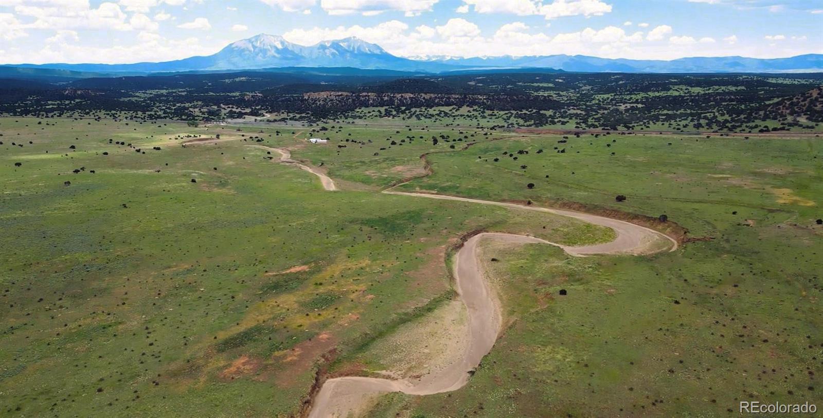 Located on the southern periphery of Walsenburg, Colorado, the Bell S Spanish Peaks Ranch offers a multitude of possibilities to the discerning buyer. The ranch spans 6,865 deeded acres (+/-) and is afforded ease of access from frontage roads that parallel Interstate 25. The Bell S is perimeter and cross fenced into (9) pastures ranging from 321 to 975-acres. In addition, the ranch contains approximately 110-acres of irrigated crop currently planted in an alfalfa/bromegrass mix and sorghum. Annual hay production for 2024 is forecasted at 1.5-tons per acre. The ranch has grazed between 475 and 525 yearlings for the last three years (Mid-May through September), while resting 2 to 3 of the pastures. It is estimated that the ranch could handle up to 700+ yearlings over the same period assuming average annual precipitation. Two gallery wells distribute water to (12) above ground stock tanks dispersed throughout the individual pastures. Well number (1) is electric powered with a dedicated meter, while well number (2) was recently upgraded to solar.  There are also several dirt tanks and ponds that gather seasonal rain fall and run-off. The ranch contains senior water rights originating from the Cucharas River. Existing improvements are grain bins, a Quonset building and a recently updated set of working pens. The ranch is afforded panoramic views to the west that include the Spanish Peaks, Sangre De Cristo and Wet Mountains. A sizable arroyo extends through the central portion of the ranch that serves as both a wildlife corridor and shelter for the livestock. Pronghorn and mule deer are common inhabitants with the occasional sighting of elk. The direct frontage and visibility along Interstate 25 presents the possibility of future commercial development. Wind, solar, or conservation easement are all possible uses. The town of Walsenburg and its amenities are a short 5 minute drive for the ranch.