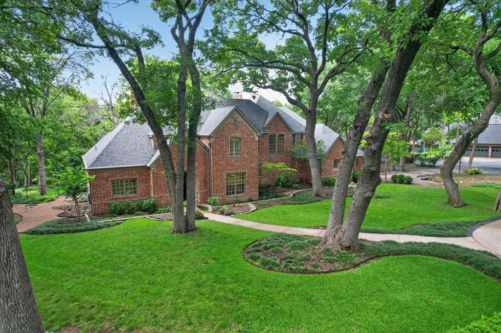 Stunning 1-acre creekside luxury estate offering privacy, elegance, and unforgettable outdoor living in highly sought after Lovejoy ISD. Lush mature trees and incredible character throughout! Tranquil and private backyard with a large covered patio, pergola with built-in grill, private side patio off the office, and large deck overlooking the creek. This exceptional home features wood flooring, four fireplaces, soaring ceilings, crown molding, dual staircases, abundant storage, wainscoting, and walls of windows that fill the home with natural light and peaceful views. The inviting living room showcases tranquil creek views, brick accent wall, and a cozy fireplace, while the elegant formal dining room includes a butler’s pantry and dry bar for effortless entertaining. Chef’s kitchen features charming brick flooring, gorgeous white cabinetry, double ovens, massive walk-in pantry, and a 6-burner gas range. Formal living room off the entry with soaring ceilings, grand staircase, and a feature fireplace. Luxurious primary suite offers wood flooring, chandelier lighting, fireplace, patio access, and space for a sitting area or desk. Spa-inspired bath with clawfoot soaking tub, oversized walk-in shower, dual vanities, and huge custom closet system. The impressive private office includes floor-to-ceiling bookshelves, custom built-ins, a dramatic black fireplace, French doors, and private patio access. Oversized laundry room with sink, abundant cabinetry, and space for an extra freezer plus a mudroom off the oversized 3-car garage. Upstairs features a decked-out media room and spacious secondary bedrooms with wood flooring, walk-in closets and a beautifully updated Jack-and-Jill bath. Tons of storage throughout including a walk-in attic. A rare opportunity to enjoy peaceful luxury living with convenient access to shopping, dining, and major highways.