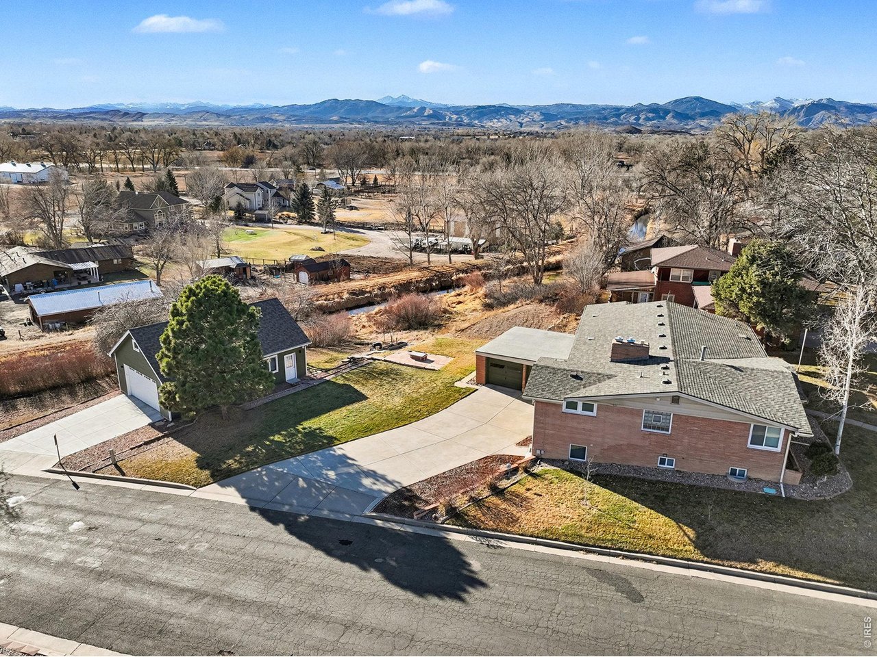 Welcome to your dream home nestled in the heart of Loveland. Not in an HOA or Metro District. This mid-century modern ranch home is a great find, combining timeless design with modern conveniences. Boasting 4 spacious bedrooms, office/study or 5th bedroom and two updated bathrooms, this brick home with an attached two car garage and a walkout basement offers the perfect blend of comfort and style. As you step inside, you'll be greeted by an inviting floor plan that showcases the home architectural details. Both living areas feature cozy gas fireplaces creating a warm ambiance. Large newer windows bathe the home in natural light while offering breathtaking views of the surrounding landscape. Abundant cabinetry in the kitchen, stainless gas stove, microwave and a breakfast nook open to the dining room. Step into the enclosed sunroom, grill year-round with the indoor barbeque grill and savor your morning coffee while soaking in the views. The expansive corner lot is perfect for outdoor activities giving you plenty of space to enjoy the great Colorado outdoors. Large detached garage/shop offers versatility for projects, vehicles or additional storage. Possibility to convert to an ADU. Recent upgrades include a newer class 4 roof (2024), newer windows, sewer line replaced, newer boiler, Mitsubishi cooling system providing comfort in all seasons, interior, exterior painting and replaced concrete driveways. Home has updated baths, spacious laundry room, Acacia wood flooring, updated countertops, lighting, is well maintained and features an exterior entrance to walk-out basement, whole house fan, troweled ceiling drywall texture and a painted mural. Located on a large lot with stunning views this home is moments away from downtown Loveland. Explore charming shops, entertainment and restaurants. Suburban tranquility and urban convenience. Wonderful opportunity to own this beautiful property.