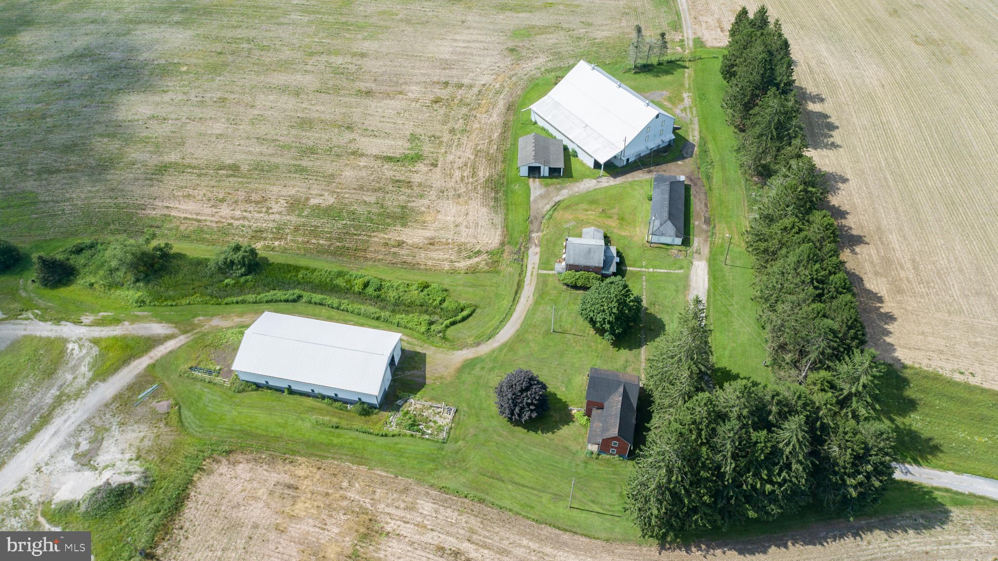 Versatile 166-Acre Property with Prime Access to I-68 and U.S. Route 219Located at the strategic junction of I-68 and U.S. Route 219, this approximately 166-acre property offers a rare combination of size, accessibility, and development potential. Currently operating as a working farm, the land includes roughly 110 acres of tillable fields, 44 wooded acres, and an established pond with a small cabin—ideal for recreational use or future enhancement.The property sits directly along the eastbound on-ramp to I-68, offering exceptional visibility and access. With public water nearby and the high-traffic corridor to Deep Creek Lake and Wisp Resort just minutes away, this site is ideally positioned for a wide range of commercial uses. Potential options include a truck stop, retail or service center, hospitality venues, or a mixed-use development. Approximately 8 acres are currently leased to a concrete barrier company, providing income and potential for industrial use in a designated section of the property.The property features seven distinct structures that add versatility and value, including a comfortable main residence, a historic 1800s farmhouse ideal for restoration or hardwood reclamation, and a large traditional barn with a full loft and stalls suited for livestock, storage, or events. Supporting agricultural and mechanical operations are a fully equipped machine shop, a spacious farm equipment garage, and a modern 40' x 100' metal building with a hydraulic crane lift, concrete floor, and high ceilings for industrial use. Rounding out the amenities is a charming cabin by the pond, perfect for recreation, weekend retreats, or rental potential.Whether maintained as a productive agricultural operation, developed into a commercial hub, or configured for a blend of both, this property offers a strong foundation in a high-growth corridor. Recreational appeal, proximity to key destinations, and diverse infrastructure make this an uncommon investment opportunity.