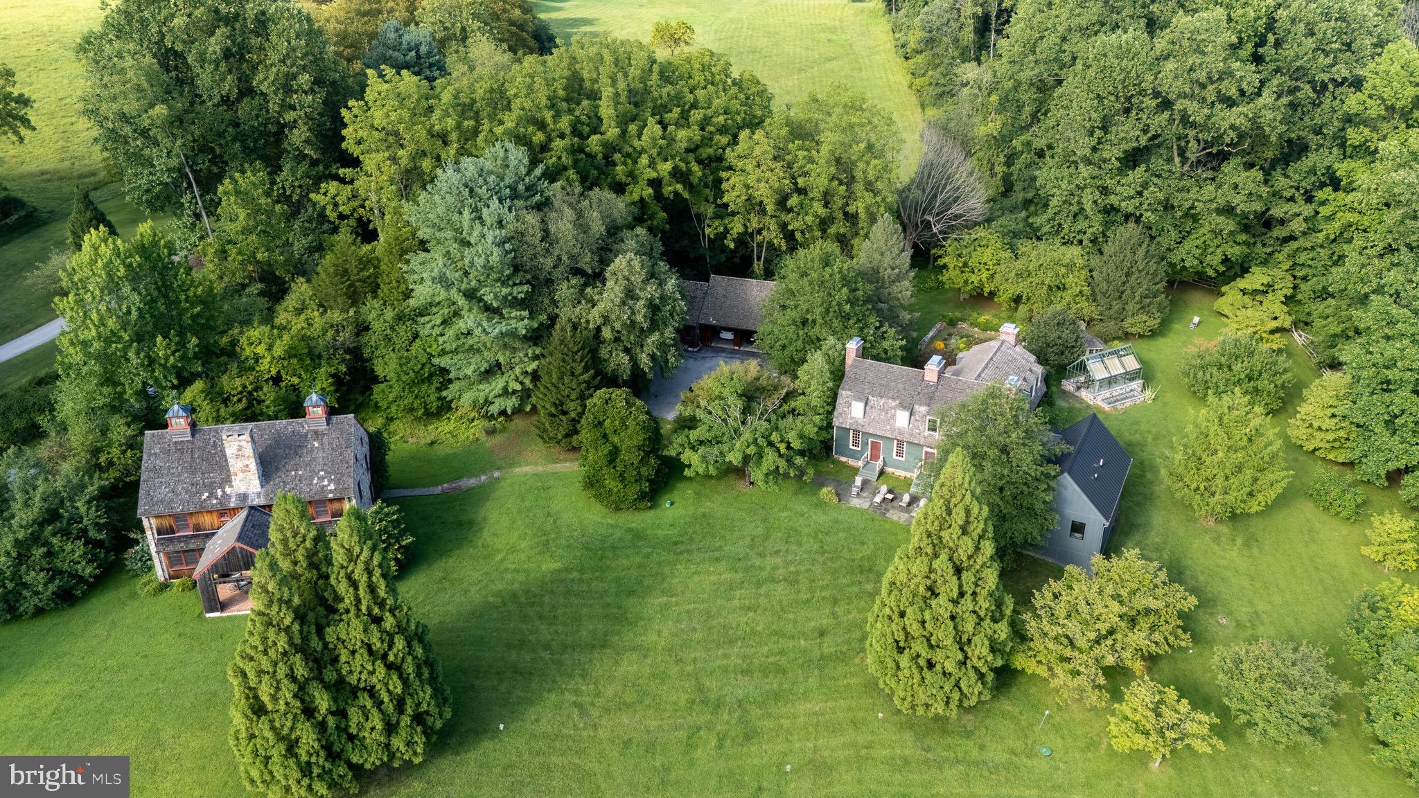 Welcome to 954 Drovers Lane, an extraordinary Chester Springs estate where history and modern design come together in an entirely unexpected way. Set on 6.3 picturesque acres along one of the area's most coveted country roads, this remarkable property offers a rare combination of architectural character, sophisticated modern living, privacy, and exceptional additional spaces.At the heart of the property is the historic Hamilton House, dating to 1751 and relocated from Maryland to its Chester Springs setting. From the exterior, the home retains the timeless character and presence of its origins, but step inside and the story becomes something altogether different.The first floor has been beautifully reimagined with a modern, eclectic point of view, creating interiors that feel fresh, sophisticated and wonderfully livable while remaining at home within the centuries-old architecture. The centerpiece is the truly exceptional renovated kitchen—a striking, design-forward space that brings together beautiful materials, modern function and distinctive style. More than simply an updated kitchen, it sets the tone for the entire first floor, where historic architecture provides the backdrop for a decidedly current way of living.A newly created first-floor primary suite continues that transformation, offering a private and beautifully appointed retreat along with the increasingly rare convenience of true one-floor living in a historic Chester County home. Thoughtfully integrated into the residence, it allows the property to live comfortably today while making it equally compelling as a home for years to come.Throughout the main residence, the contrast is part of the magic. Original character, fireplaces and architectural details coexist effortlessly with contemporary finishes, unexpected design choices and comfortable gathering spaces. The result isn't a historic home trying to recreate the past, but rather one that celebrates its history while confidently embracing the present.Beyond the main residence, the property becomes even more special. A separate 2,000+ square-foot building offers extraordinary flexibility for entertaining, guests, a home office, studio, creative retreat or any combination of uses. An expansive open living area, kitchenette, full bath, dramatic two-story fireplace and covered porch with an additional fireplace create a space that feels like a destination of its own.A detached three-car garage, greenhouse, mature landscaping and thoughtfully designed outdoor spaces complete the property, while the surrounding acreage provides the privacy, beauty and peaceful sense of place that define Chester Springs country living.954 Drovers Lane is not simply a historic home, nor is it simply a beautifully renovated one. It is the rare meeting of old and new—a centuries-old exterior surrounding interiors that are imaginative, modern and completely of the moment, all within a remarkable 6.3-acre estate compound.For the buyer looking for something that cannot be replicated, this is exactly that.