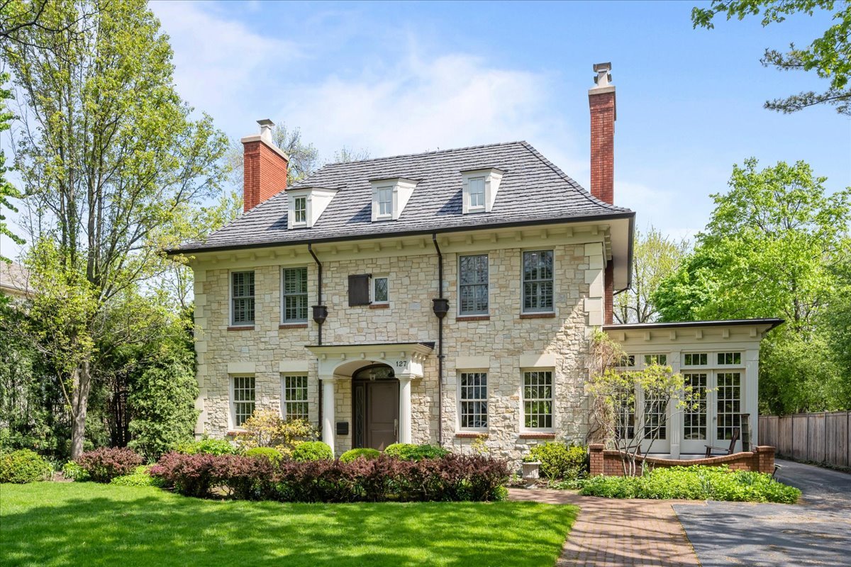 Solid stone construction, classic architecture, timeless design and refined living come together in perfect harmony in one of the most coveted and convenient locations in Winnetka/ Hubbard Woods with close proximity to town, train and Lake Michigan. Built in 2006 by Adamczyk Fine Homes and Interiors offering three levels of unparalleled craftmanship and quality totaling almost 7000 square feet. Step into the foyer with its stunning custom staircase, leading to a sun-drenched living room with fireplace and a beautifully paneled office. The spacious elegant dining room, complete with its own fireplace and a butler's pantry featuring both wine and beverage refrigerators, sets the stage for unforgettable gatherings. The gourmet kitchen is a chef's dream, boasting an oversized island, and a separate breakfast area. It seamlessly flows into the family room, where built-in bookcases, a fireplace, and French doors open to a serene bluestone patio and sizable fenced private backyard. Functional and practical mudroom/laundry room connects to the attached two-car garage. Upstairs, the sunlit second floor offers a luxurious primary suite with spa-like bath, and dual walk-in closets. There are four additional comfortable bedrooms.  The fifth bedroom can be flexible space as a private sitting room (or extra 15 x 14 walk-in closet for the primary suite), Two more bathrooms complete the upper level.  The deep pour lower level with high ceilings is a retreat of its own, featuring a stone wine room, two recreation areas, the sixth bedroom with full bathroom, exercise room, and storage.  Outside, the meticulously landscaped grounds provide a picturesque backdrop for this extraordinary home. With its refined details, quality materials, flowing floorplan, and thoughtful design, this property offers a perfect blend of sophistication and comfort. Truly, a forever home that will stand the test of time! New Brava Synthetic Composite Roof 2025, 2 new ACs 2022 & 2020, furnace 2023.