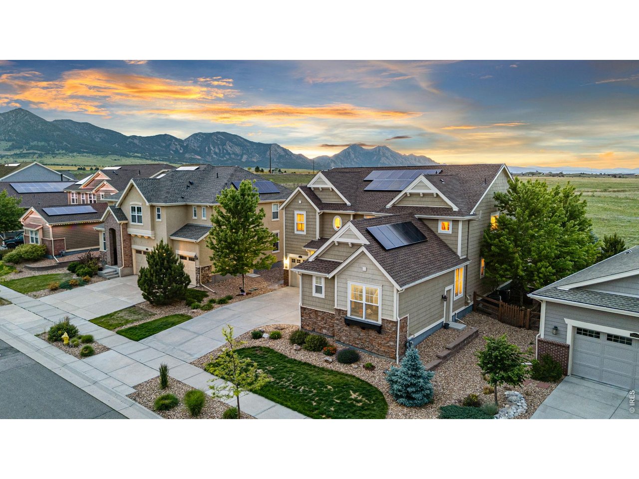 Perched on one of the most coveted lots in Arvada, this stunning Lennar Prescott offers breathtaking, unobstructed views of protected open space & the mountains. Built in 2017 & thoughtfully designed throughout, this 5-bedroom, 5-bathroom home features 3,500+ square feet of living space and a 3-car garage. A spacious foyer welcomes you while the great room showcases dramatic two-story ceilings & oversized picture windows that perfectly frame the spectacular views. The open-concept layout seamlessly connects the great room, dining area, and kitchen, creating an ideal space for both everyday living & entertaining. The gourmet kitchen features granite countertops, tile backsplash, upgraded appliances, abundant cabinetry, and a large center island accented with a custom reclaimed-wood finish. Just beyond the kitchen, a butler's pantry & dining room provide additional functionality & entertaining space. The dining room is highlighted by upgraded lighting, a tray ceiling, and a reclaimed-wood feature wall. The main level also includes a private office, mudroom, and a guest suite with its own full bathroom. Upstairs, you'll find four additional bedrooms, including the large primary suite. Wake up to panoramic views of open space and the Flatirons through expansive picture windows, complemented by a custom blue-pine tray ceiling. The five-piece primary bath features a soaking tub, oversized shower, and large walk-in closet. The conveniently located laundry room is accessible from the primary suite. A secondary bedroom with a full bath is tucked behind custom barnwood doors, while two additional bedrooms share a Jack-and-Jill bathroom with separate vanities & generous closet space. Step outside to the covered deck and enjoy your private backyard retreat, complete with a hot tub, fire pit & unmatched Colorado views. Residents enjoy access to 13.5 miles of trails, parks, swim & fitness centers, tennis courts, & an on-site K-8 school, all just steps from home.