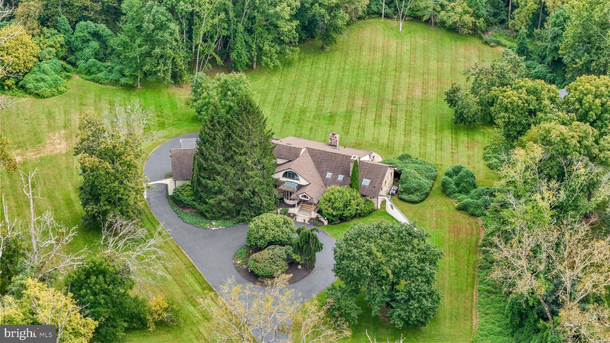 Some homes are designed to be surrounded by nature. Foxes Run is designed to belong to it.Nestled on 7.4 premier acres in coveted Radnor Township, in the heart of the Main Line, this secluded estate offers a rare combination of land, privacy, and a residence that lives in conversation with the woods around it, all within easy reach of downtown Philadelphia. Arrival sets the tone. A private drive crosses a quaint bridge over Foxes Run, the creek that gives the property its name, then bends through lush landscaping and opens into a circle before the house, an architectural masterpiece by Alex Messinger, with interiors by John Herman, hidden entirely from the road. Held by one family for more than three decades and shaped around the way they wanted to live. Flat, wooded, and threaded by water, the setting is one of one, almost impossible to replicate anywhere on the Main Line. Step through the front door and the house turns outward. In the living room, two walls of windows wrap toward a gorgeous fireplace, so the trees are present from the moment you arrive. The dining room follows, framed in oversized windows above the front grounds. Then the house widens into the kitchen, its true center, custom baked-enamel cabinetry, a generous center island, side-by-side 19-cubic-foot refrigerator and freezer, and dual dishwashers, which opens into a glass conservatory large enough to seat the full table, two stories of windows on every side. Deer at the tree line, hawks and bald eagles overhead: the view changes daily and never repeats. Beyond the kitchen, everyday life is handled with equal grace. A generous mudroom absorbs the business of coming and going, with a half bath, direct access to the rear patio, entry to the oversized three-car garage, and a discreet back staircase to the apartment above it. The opposite wing belongs entirely to the primary suite, a rare first-floor retreat where an exposed stone wall carries through both bedroom and bath, lending the rooms a sense of age and permanence. A private deck opens directly to the lawn. The spa-like ensuite answers with a soaking tub, stall shower, and dual vanities. Downstairs is the heart of the home: a stone fireplace, a sitting area scaled for real gathering, dual sliders that open the entire room to the backyard, a walk-in laundry room, and a full bath. A level below, the house keeps going, playroom, game room, oversized storage, and a home gym anchored by a dry sauna with an oversized heater for rapid heat-up, the adjacent shower piped for steam. Upstairs, three generously proportioned bedrooms share a hall bath, each looking out into the treetops. A half staircase rises to a quieter corner of the house, an additional bedroom, another full bath, and a private office with its own patio above the front grounds. This level also connects to the apartment over the garage, complete with kitchenette, sitting area, full bath, and its own stairway back down to the mudroom, offering guests or extended family genuine independence. Six bedrooms and six and a half baths in all. But the land is the story. Play in the creek. Watch the wildflowers come in each spring. Catch the fireflies lifting off the meadow on a June evening. Walk the property line and hear nothing at all. Land like this was once ordinary on the Main Line. It isn't anymore. Room for horses. Room to build. Room for whatever the next chapter asks for. All of it within the award-winning Radnor Township School District.Private. Elevated. Almost impossible to replicate. Welcome to Foxes Run.Buyer to verify all zoning requirements and permitted uses with Radnor Township.