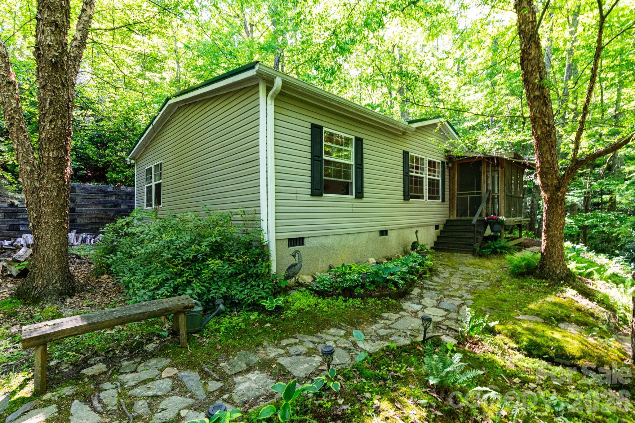 Nestled on 2.03 wooded and private acres in beautiful Fairview, this well-maintained 3-bedroom, 2-bathroom home offers peaceful mountain living at its best. Surrounded by mature trees and natural shade, the property provides a serene sense of privacy while still being close to local conveniences. Only 15 minutes to the local grocery store, 30 minutes to downtown Asheville, and 35 minutes to the Asheville Airport. Inside, you’ll find a comfortable and inviting layout with plenty of natural light, spacious bedrooms, and a warm, welcoming feel throughout. Whether you’re enjoying quiet mornings on the screened-in porch, exploring your own wooded retreat, or simply soaking in the tranquility, this Fairview home is the perfect blend of comfort, nature, and easy living.