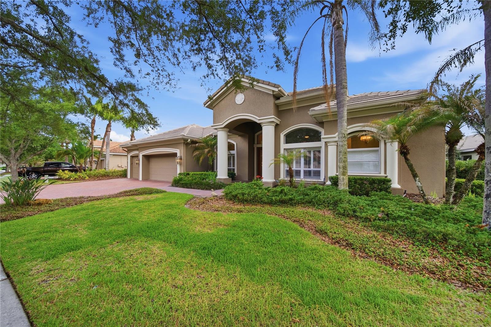 Nestled within the gated enclave of Lancaster in Tampa Palms, this exceptional estate residence offers an elevated blend of timeless elegance and modern luxury. Featuring 4 bedrooms, a private office, 3.5 baths, and a 3-car garage, this meticulously curated executive pool home is gracefully positioned on a serene pond-front homesite. Thoughtfully redesigned with impeccable attention to detail, the residence showcases soaring ceilings, rich hardwood flooring, bespoke millwork, and picturesque water views throughout.The gourmet chef’s kitchen is a true centerpiece, appointed with an expansive leathered granite island, custom cabinetry with crown molding, double wall ovens, gas cooktop, dual wine refrigerators, and designer lighting selections that create both warmth and sophistication. The spa-inspired bathrooms feature luxurious granite finishes, refined fixtures, and elegant design elements throughout.A desirable split-bedroom floor plan provides both comfort and privacy, including two secondary bedrooms connected by a beautifully updated bath, a secluded guest ensuite, and an indulgent owner’s retreat complete with a sitting area, custom walk-in closet, and a lavish bath featuring a soaking garden tub and oversized walk-in shower.Designed for effortless indoor-outdoor living, the expansive pavered lanai overlooks a sparkling resort-style pool and tranquil pond views — an idyllic setting for entertaining or quiet relaxation.Recent enhancements include upgraded landscape lighting, AC (2021), water heater (2022), pool motor (2022), water softener, and a beautifully reimagined laundry room.Residents enjoy exclusive access to Club Tampa Palms amenities including resort-style pools, fitness center, spa, sauna, tennis courts, and more. Ideally located near premier shopping, fine dining, Moffitt Cancer Center, VA Medical Center, USF, and offering convenient access to downtown Tampa via I-75 and I-275.A rare opportunity to own an impeccably maintained luxury residence in one of Tampa’s most sought-after gated communities.