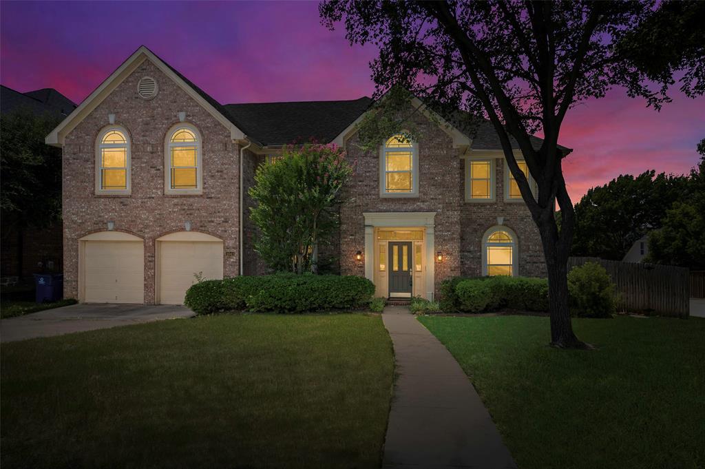 Charming Corner-Lot Home Near Grapevine Lane & DFW Airport. Nestled on a beautifully landscaped corner lot, this spacious and inviting home offers the perfect blend of elegance, functionality, and location. Shaded by a mature, stately tree, the property enjoys natural cooling and scenic curb appeal. Step through a grand entryway into a thoughtfully designed layout featuring a dedicated study with custom built-in shelving—ideal for a home office or library. Adjacent to the entry, formal living and dining rooms provide a graceful setting for entertaining, with direct access from the dining room to a kitchen designed for serious cooks. The kitchen boasts abundant cabinet space, a built-in desk area, a cooktop, and a cozy casual dining nook. The living room is a warm gathering space with a gas fireplace, built-in shelving, and a wet bar—perfect for relaxing or hosting guests. Expansive windows fill the home with natural light, enhancing its open and airy feel. Upstairs, a large flex space offers endless potential for a game room, media room, or additional living area. The generously sized primary suite features a luxurious en-suite bath with dual vanities, a large soaking tub, an oversized walk-in closet, and a distinctive built-in sliding mirror. Outside, the spacious grassy backyard is ideal for play, pets, or future outdoor living upgrades.