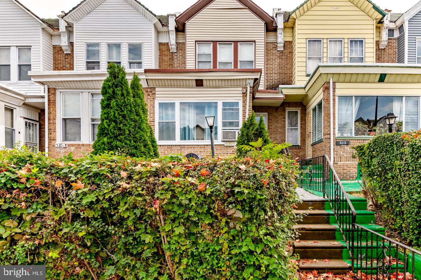 Welcome to W Berks St, a spacious and versatile classic rowhome in Philadelphia offering incredible character and flexible multi-level living. Step onto the elevated front porch into a light-filled, fully enclosed sunroom featuring durable flooring a perfect welcome space, mudroom, or sun-drenched home office. Inside, the main level opens to a sprawling living room adorned with warm hardwood floors, an elegant decorative fireplace mantle, a custom mirrored accent wall, and a traditional spindled staircase. An open archway leads into a formal dining room equipped with a central lighting fixture and flexible floor space for entertaining. The contiguous kitchen offers wood cabinetry, gas cooking, and tile backsplash, with convenient direct access to a dedicated main-floor laundry room with full-sized washer and dryer hookups. Upstairs, bright bedrooms feature polished hardwood flooring, ceiling fans, ample natural light, and deep mirrored sliding closets with upper storage shelves. The main full bathroom exhibits classic blue ceramic wall tile, a pedestal basin, and a soaking tub/shower combination. The finished lower level dramatically expands your functional footprint, featuring extra flexible living/sleeping quarters, a secondary full bathroom, a utility sink area, and generous dedicated storage. Ideal for primary owners seeking layout options or investors expanding a rental portfolio!