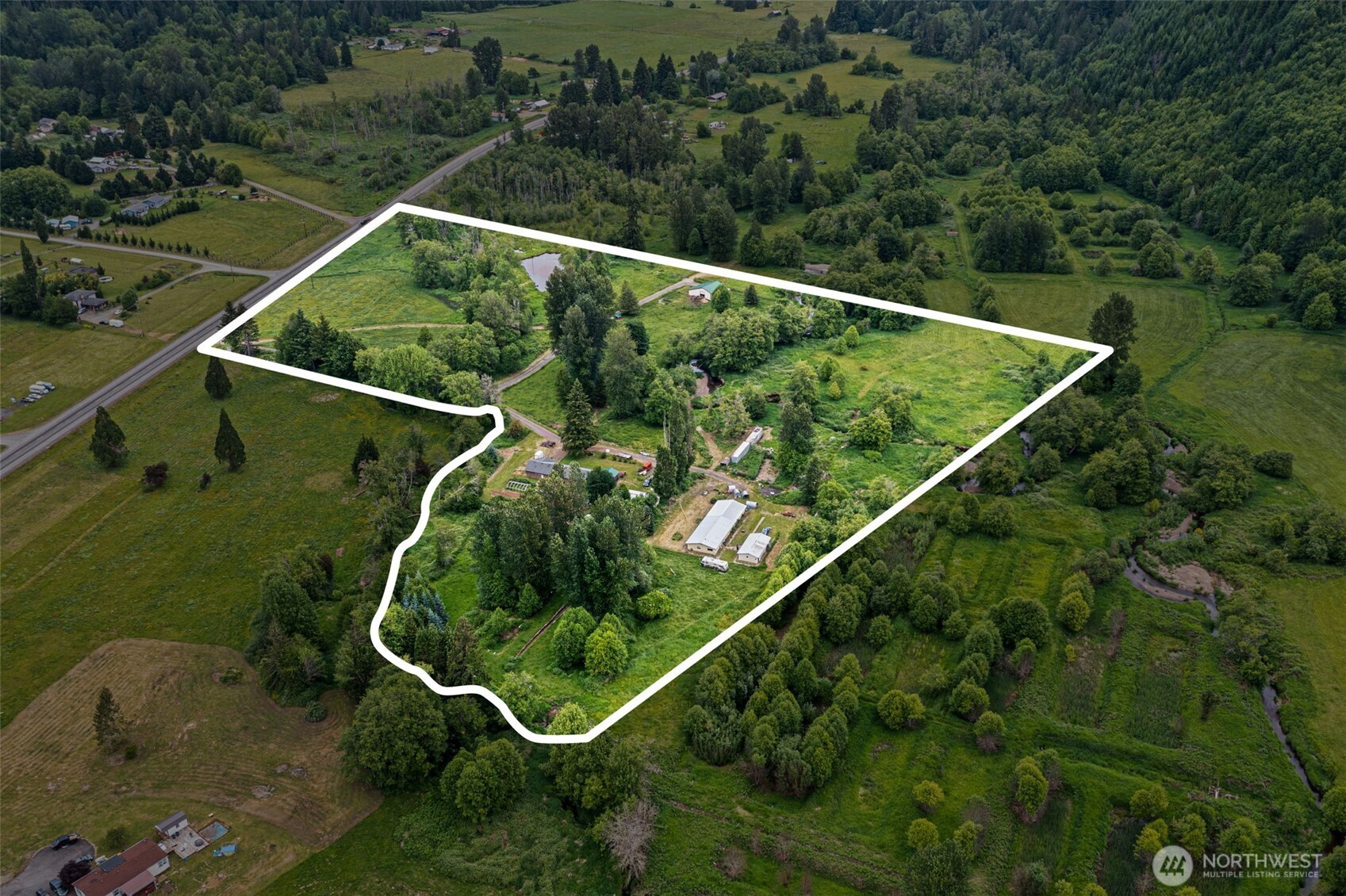 Subdividable 21+ acres* Rainy and Lunch Creeks run through property* Pond* Barn with kitchen (raw milk storage), half bath, 400 amp service* 30x90 shop w/400 amp service + 2 br/1 bath apt (needs renovation)* Meat processing room w/walk in cooler powered by Cool bot (meat saw does not convey) w/400 amp service* 32x64 implement shed currently used for grain storage w/400 amp service* Garden space* Chicken coop* RV parking & cover* Electric fence on pasture* 3 br home features new laminate flooring, mini split, wood stove, fully functional wood cooktop stove in addition to electric range, 200 amp service, upgraded fixtures and LED lighting, new counters/backsplash in kitchen, new dual pane windows, patio* Fruit trees and bushes incl: apple, plum, pear, cherry, elderberry, thornless blackberry, grapes, strawberries, raspberries, rhubarb* Circular drive with covered bridge*