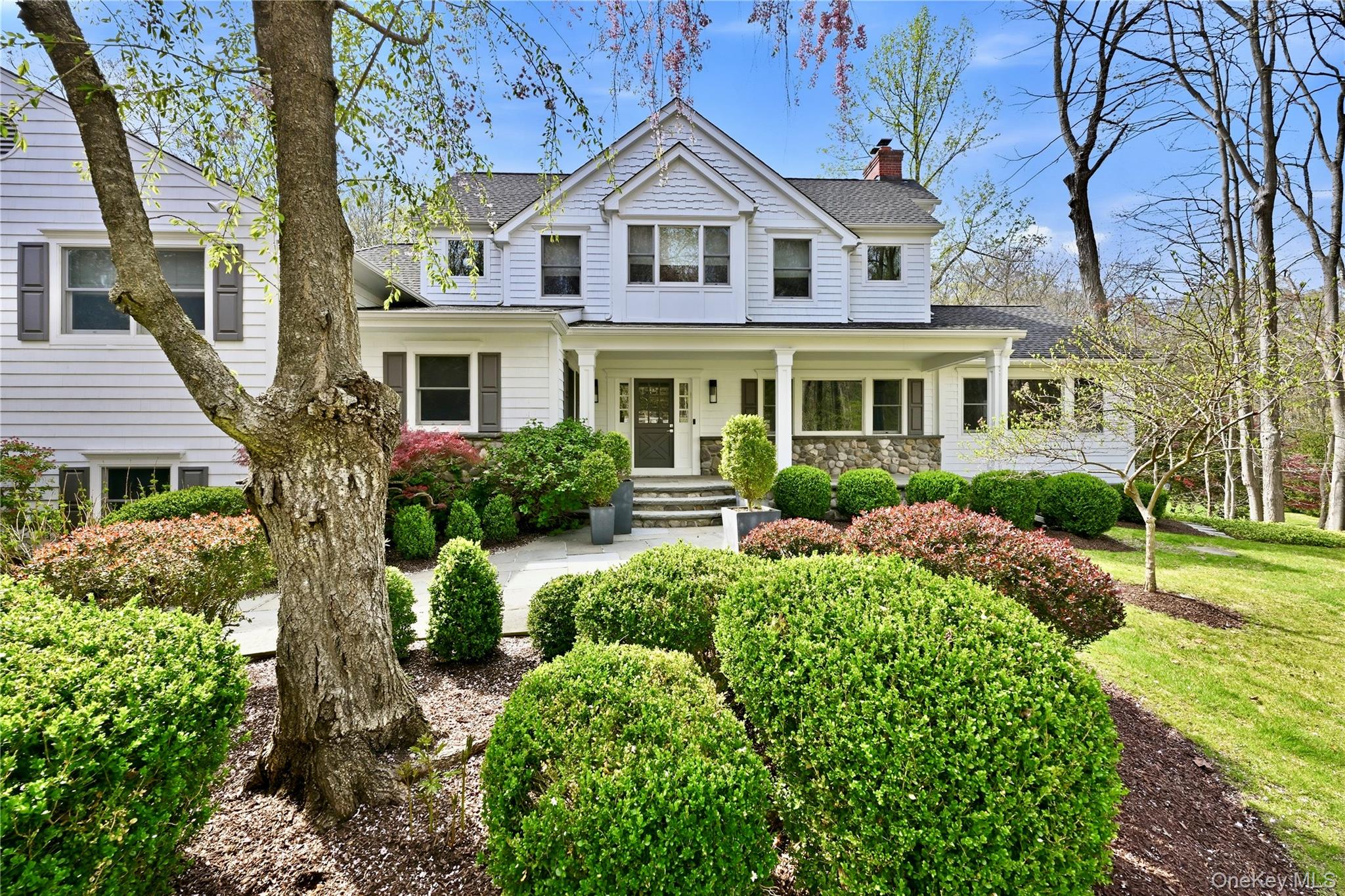 Welcome home to the ideal Windmill Farm lifestyle in the heart of Armonk, where summers at the Windmill Club mean swimming, boating, playing tennis, and relaxing on the beach.Set back on over 2.65 beautifully flat, landscaped acres, this thoughtfully renovated 4-bedroom-plus home is defined by its charming covered front porch and dutch door entry that open to an inviting foyer. The chef’s kitchen flows into a fabulous breakfast area with a cathedral ceiling and walls of windows overlooking the backyard, and continues seamlessly into the family room and the dining room with French sliding glass doors creating the perfect setting for everyday living and entertaining. The main level also offers two private offices, providing exceptional flexibility for today’s lifestyle needs. The lower level features a superb home gym, a great recreation room, a media room, and a laundry room, offering outstanding additional living and entertaining space. All closets are custom designed, and no detail has been spared throughout the home.  There is also a bedroom and bathroom with no step entry off the garage. Outside, enjoy a small garden, a porch off the office, and a large entertaining patio with an outdoor TV overlooking an ideal suburban backyard setting. With tasteful updates throughout and a fantastic layout, this is a very special Windmill Farm home not to be missed.