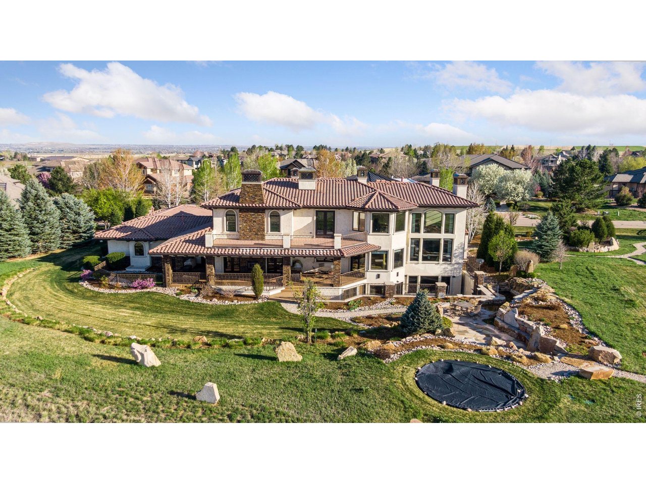 An architectural masterpiece in the prestigious Legend Ridge community of Niwot, this extraordinary residence delivers a true five-star living experience. Thoughtfully designed to showcase sweeping, unobstructed views of the Rocky Mountains, the home seamlessly blends refined luxury with the beauty of its natural surroundings. The property abuts private open space with miles of scenic trails just beyond your door-and only minutes from charming downtown Niwot and top-rated public and private schools. Every detail reflects exceptional craftsmanship and quality. A grand great room welcomes you with soaring ceilings and walls of windows that frame breathtaking peaks. The chef's kitchen features an oversized island, 8-burner/double over range, Subzero fridge and an inviting in-kitchen dining area, while a sophisticated formal dining room-anchored by a fireplace and French doors-opens effortlessly to the back patio for seamless indoor-outdoor living. Two main-level offices provide both flexibility and functionality for working from home. An elevator or curved staircase leads to the luxurious primary suite retreat, complete with a private lounge, view-filled deck, cozy fireplace, and a spa-inspired bath with steam shower, soaking tub, and expansive custom closet. Upstairs, two additional en suite bedrooms and a well-appointed laundry room with four machines offer elevated comfort and convenience. The lower level is designed for both entertainment and wellness, featuring a gym, private theater, recreation space with room for a pool table and sports lounge, a card nook, and a large bar with seating, along with a wine storage and tasting room. Two additional bedrooms with beautifully appointed baths complete the level. A six-car heated garage accommodates every storage need. Meticulously designed gardens with tranquil water features create an idyllic backdrop for outdoor entertaining under the open sky. This exceptional Niwot estate embodies the very best of Colorado living.