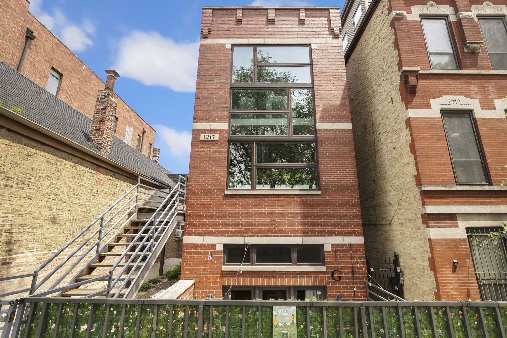 You have to see this one to believe it! With 14-foot ceilings, massive windows and a prime Wicker Park location, this beautiful condo, nestled into quiet and leafy Greenview Avenue yet just a couple of blocks from public transportation, provides it all. Just two blocks from the Division Blue Line Station and all the trappings of Wicker Park, enjoy the perfect mix of personal privacy and connectivity to the city you love. From the moment you walk in, this light-filled unit welcomes you home with soaring ceilings and a wide-open living, dining and kitchen combination held together by beautiful hardwood floors which carry throughout the unit. Large front windows with bookend doors send you directly outside to your large, refinished and private deck, making entertaining an absolute experience. There's room for everyone and any configuration you like with the living space anchored by a beautiful gas fireplace. Quartz countertops and stainless steel appliances anchor the right-sized kitchen, complete with bar seating for a few.  Roll down the hallway to the two tucked-away bedrooms, including primary en suite with whirlpool tub, separate shower & twin sinks. The second bedroom features a smart Murphy bed, the ultimate convenience, allowing this room to double as an office and a guest room. Amenities include in-unit laundry, a dog run and parking in back. They alley is just one way in, providing safety and security. The building sits two blocks from Pulaski Park and neighbors schools and the Division & Milwaukee corridors. With immediate public transport options, including I-90/94 just a couple of minutes away, this location can't be beat! Come see it right away!