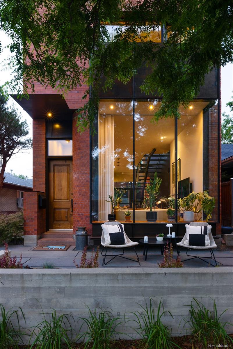 An architectural statement in the heart of Lower Highland, 2448 W 32nd Ave is an exceptional custom home designed by Denver's acclaimed BOSS.architecture. Built with intention and thoughtfully integrated into the context of the neighborhood, the residence is both timeless & modern, featuring custom steelwork throughout, a striking 11' paneled glass facade, and a red brick exterior. Recent updates honor the home's original design and craftsmanship, including a new Trex rooftop deck with built-in perimeter seating, new wool carpeting on the upper & lower levels, and an updated kitchen with leathered granite countertops, a new Electrolux refrigerator & gas cooktop, and a new sink & faucet. The rear patio was refinished, fresh landscaping installed, and many cosmetic improvements completed throughout. The main level is open yet intimate, with lofted ceilings and diffused natural light from 6 skylights filtered through an open-riser staircase with frameless glass guardrails. Minimalist details create an airy aesthetic, while an amber kitchen backsplash and charcoal west wall add warmth & elegance. Upstairs, the primary suite is filled with soft, indirect light. The primary bath features white penny tile extending into the walk-in closet with stacked laundry. A window-lined office anchors the south end of the floorplan, while an additional full bath serves guests & the rooftop deck. The basement offers a spacious bedroom with its own full bath. Outdoor spaces include a private main-level patio with a water feature & mature trees, plus a 436 sq.ft. rooftop deck designed for entertaining. An elevated bridge connects the deck to the home, one of its most distinctive architectural features. The detached 2-car garage offers space for vehicles & outdoor gear. Centrally located in LoHi, the home is steps from many of Denver's celebrated restaurants, with convenient access to I-25, I-70, the mountains & DIA. A rare opportunity for discerning buyers seeking something exceptional.